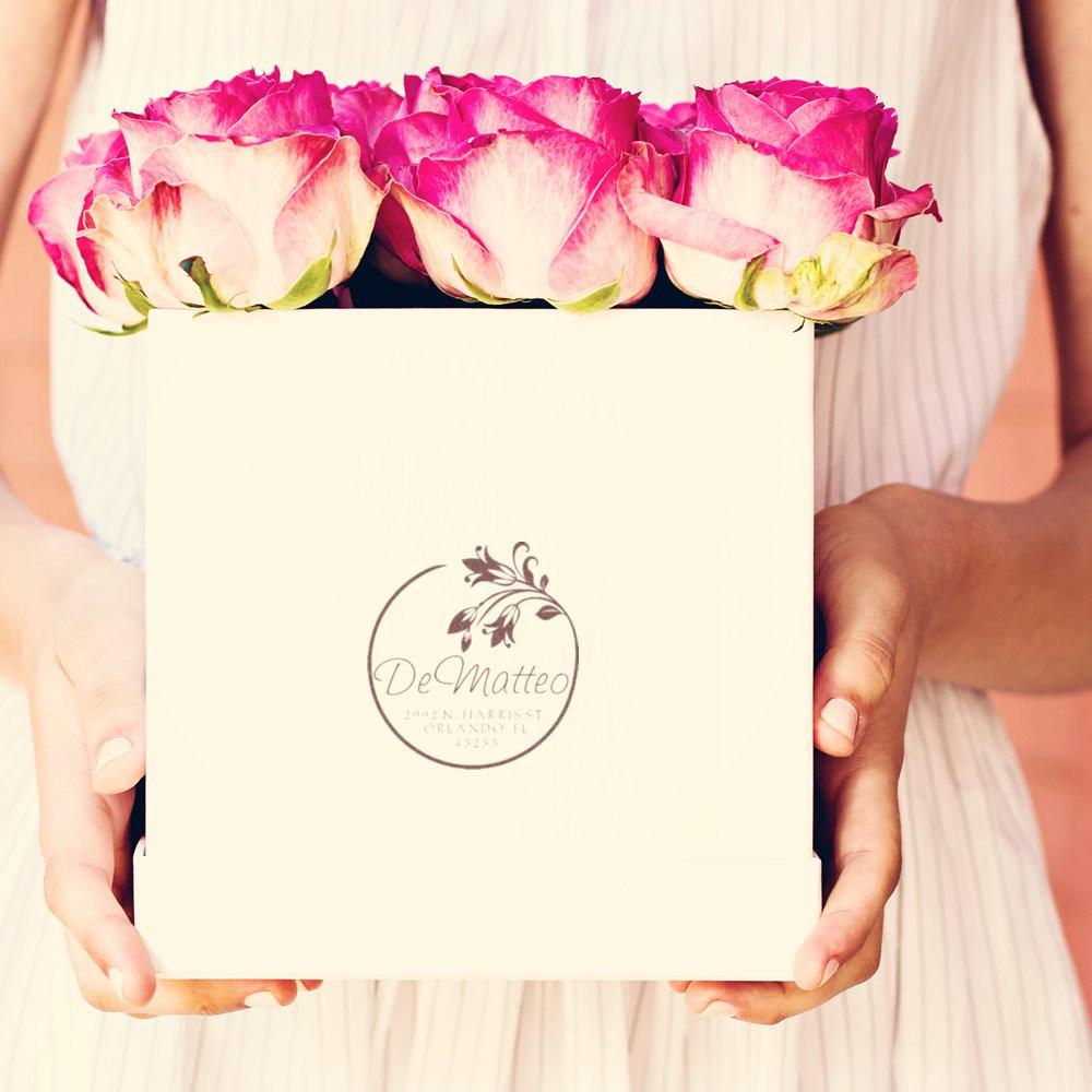 Personalized floral rubber stamp on a wedding gift box with pink roses, featuring the DeMatteo monogram logo.
