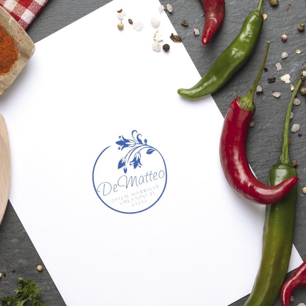 Custom round rubber return address stamp for food packaging, shown on paper with chili peppers and spices.