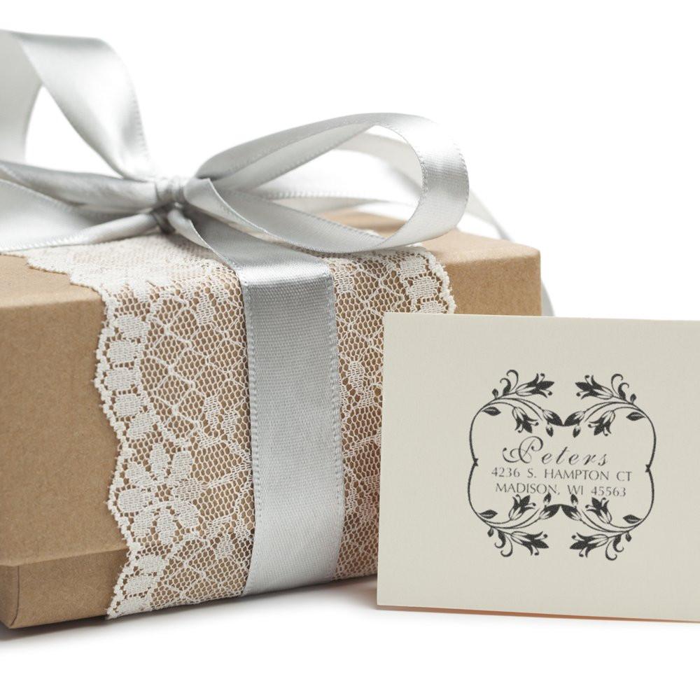 Custom address rubber stamp for elegant gift packaging, shown with a wrapped present, lace ribbon, and personalized return address card.