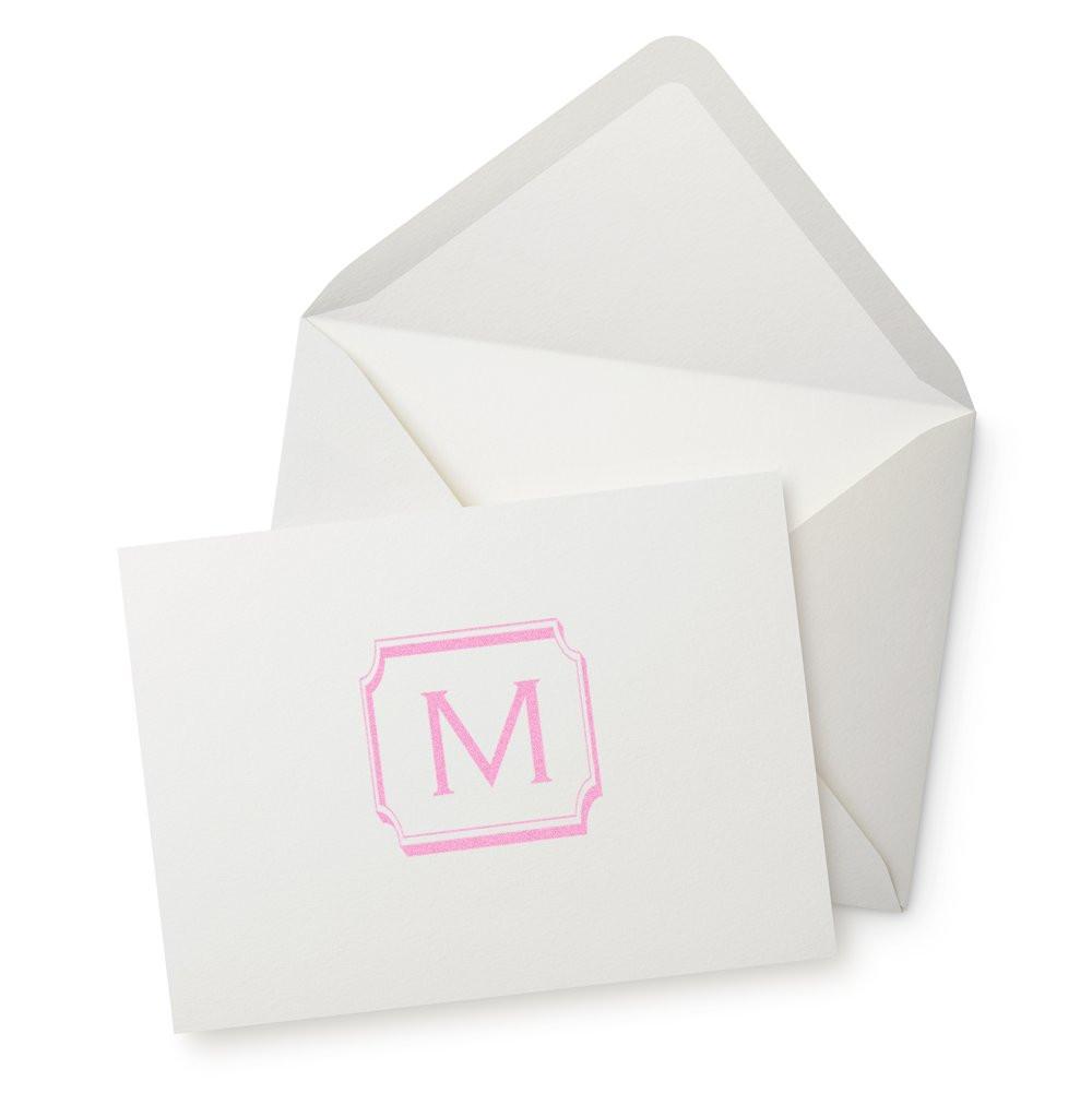 Pink monogram rubber stamp on white invitation card with envelope, ideal for custom wedding stationery.