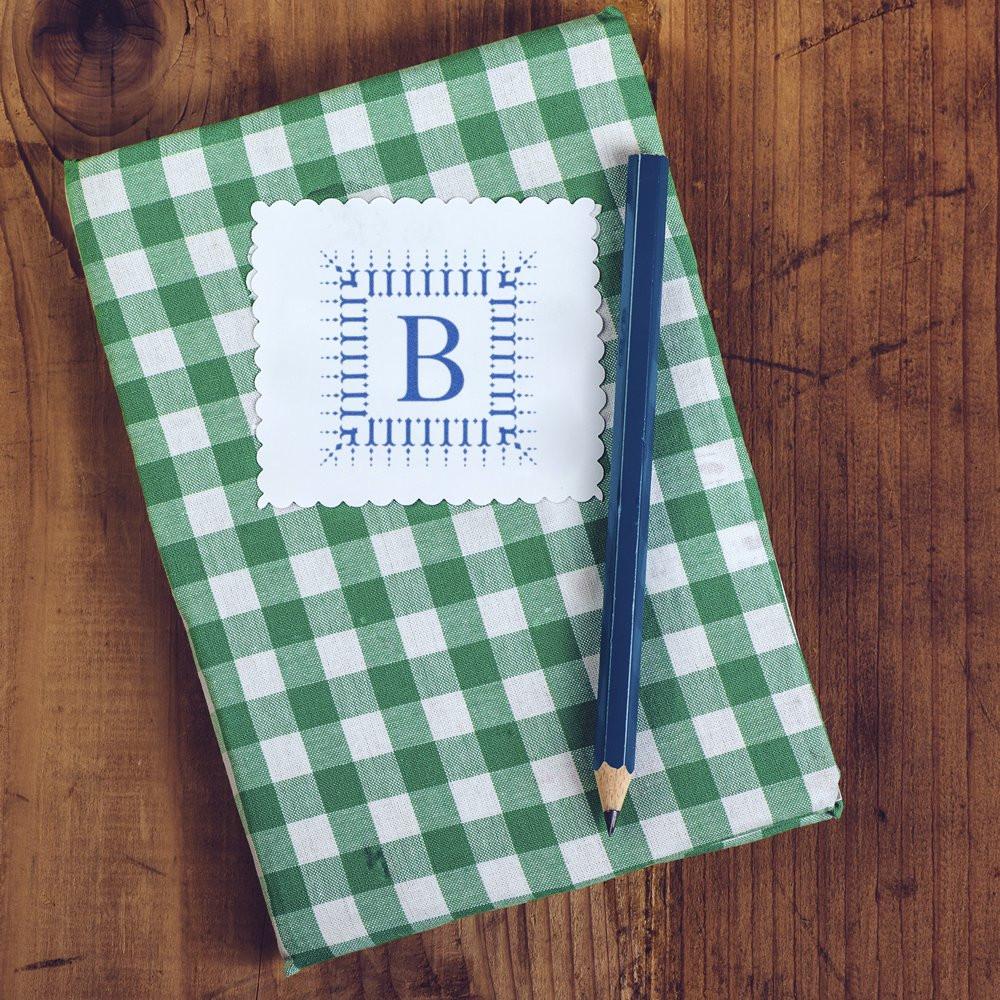 Custom monogram rubber stamp with letter B on scalloped paper, ideal for personalized stationery and gift tags.