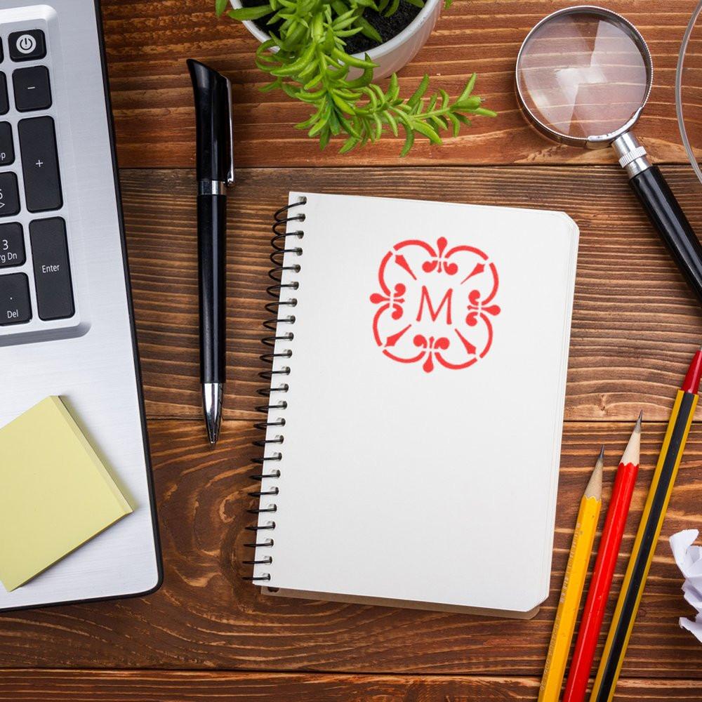 Custom floral monogram rubber stamp on notebook, perfect for personalized stationery and branding.