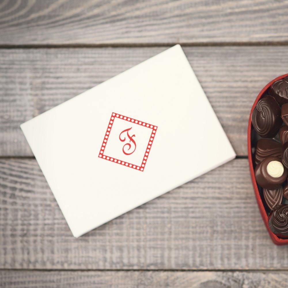 Custom monogram rubber stamp on a white envelope, perfect for personalized wedding stationery and gift packaging.