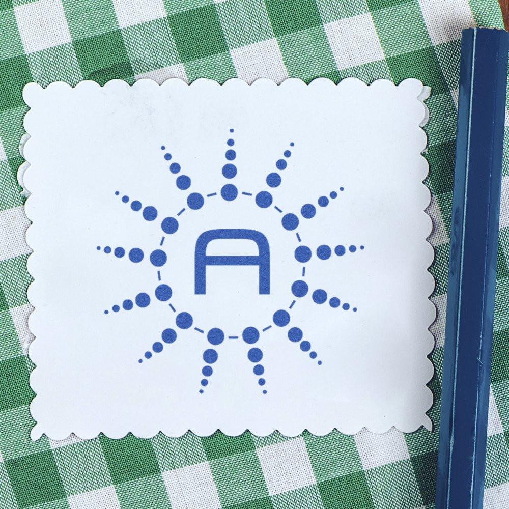 Custom rubber stamp impression with blue dotted sunburst logo on scalloped white card.