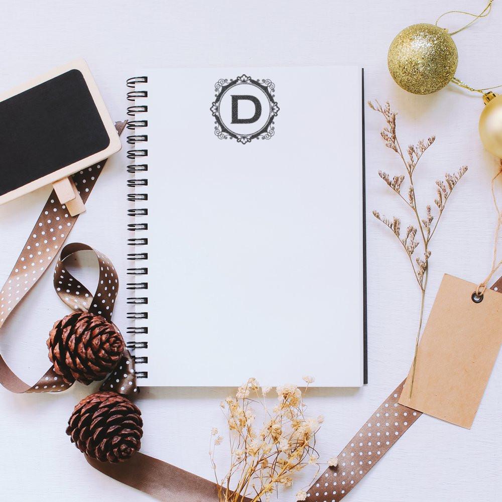 Monogram D rubber stamp on a spiral notebook, ideal for custom stationery, holiday crafting, and branding projects.