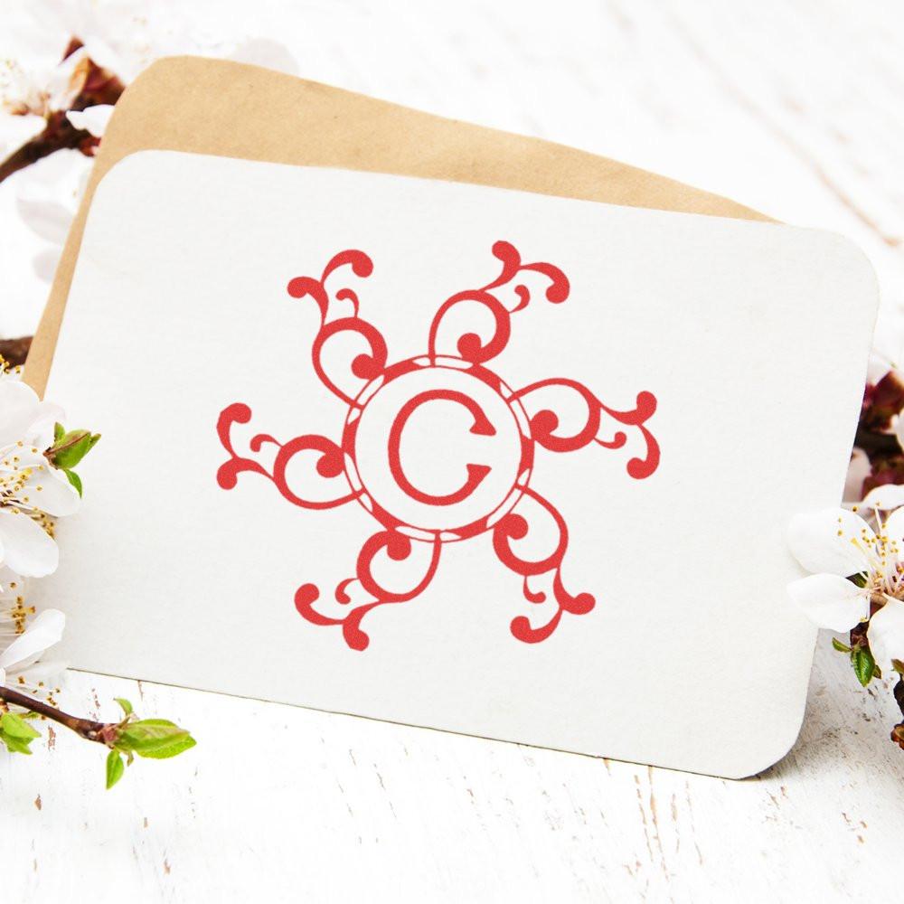 White greeting card envelope with red ornamental monogram G, surrounded by spring flowersperfect for birthdays and holidays.