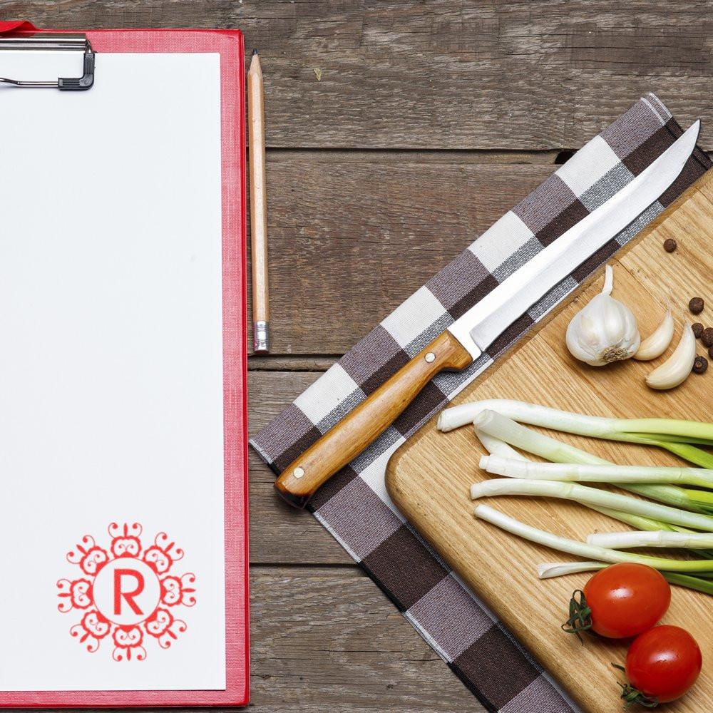 Custom monogram rubber stamp with decorative letter R on clipboard, ideal for personalized stationery and recipe branding.