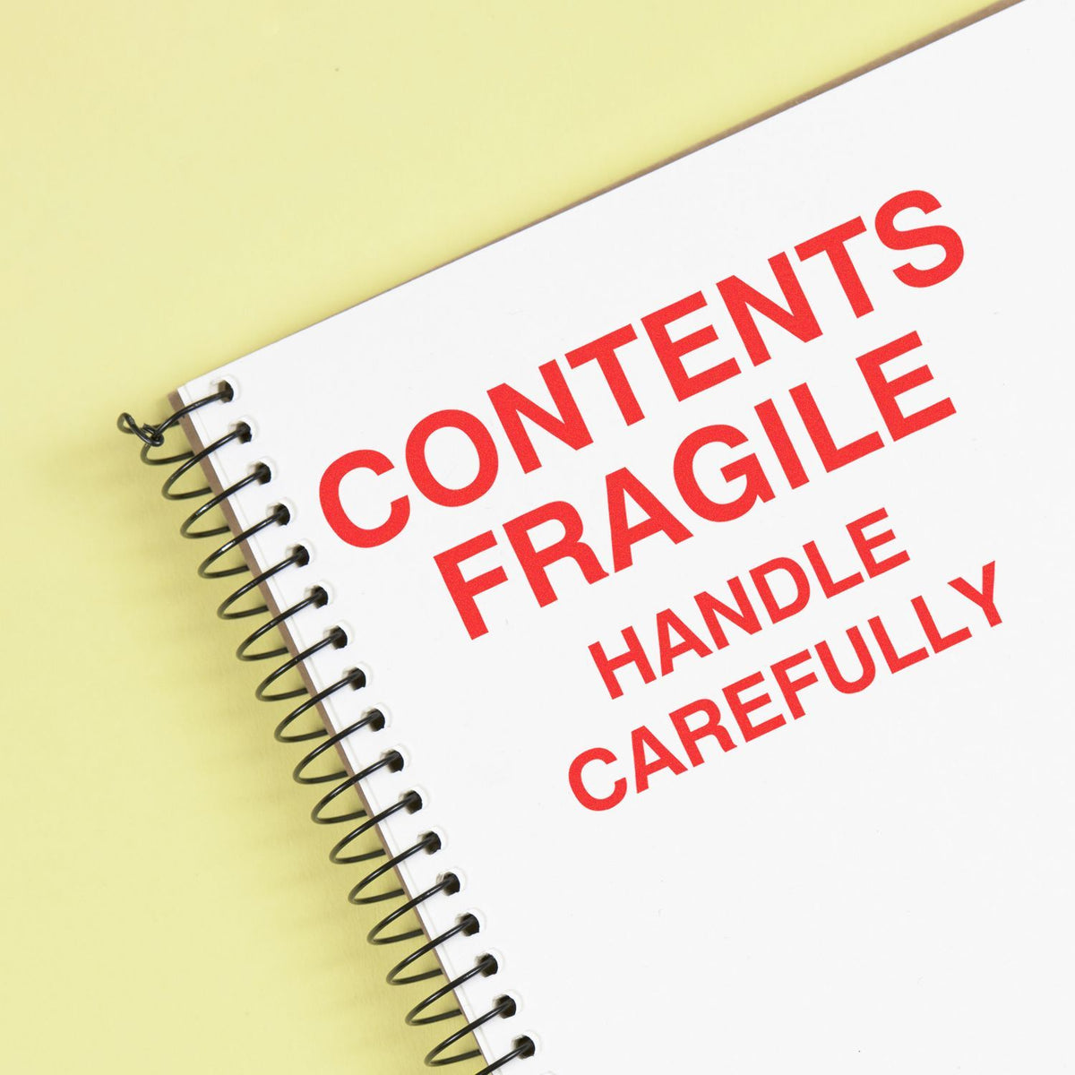 Notebook cover shows Contents Fragile Handle Carefully shipping warning for protecting fragile goods during handling and delivery.