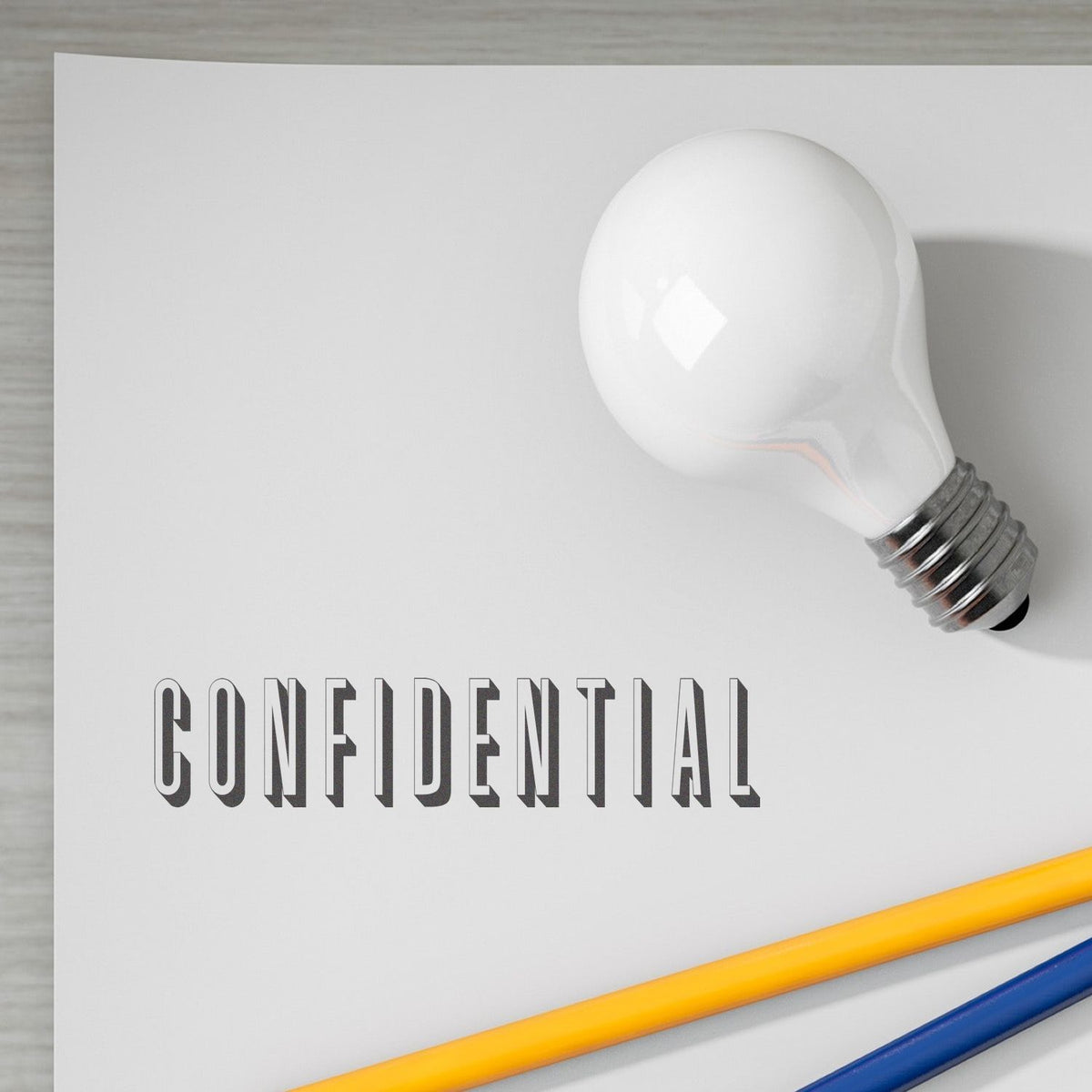 Light bulb over white background with CONFIDENTIAL label, highlighting sensitive information privacy and business security