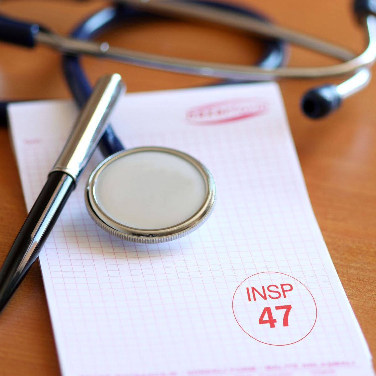 Magnifying glass over inspection checklist form with INSP 47 stamp on grid notebook paper, highlighting audit, quality control, compliance review.