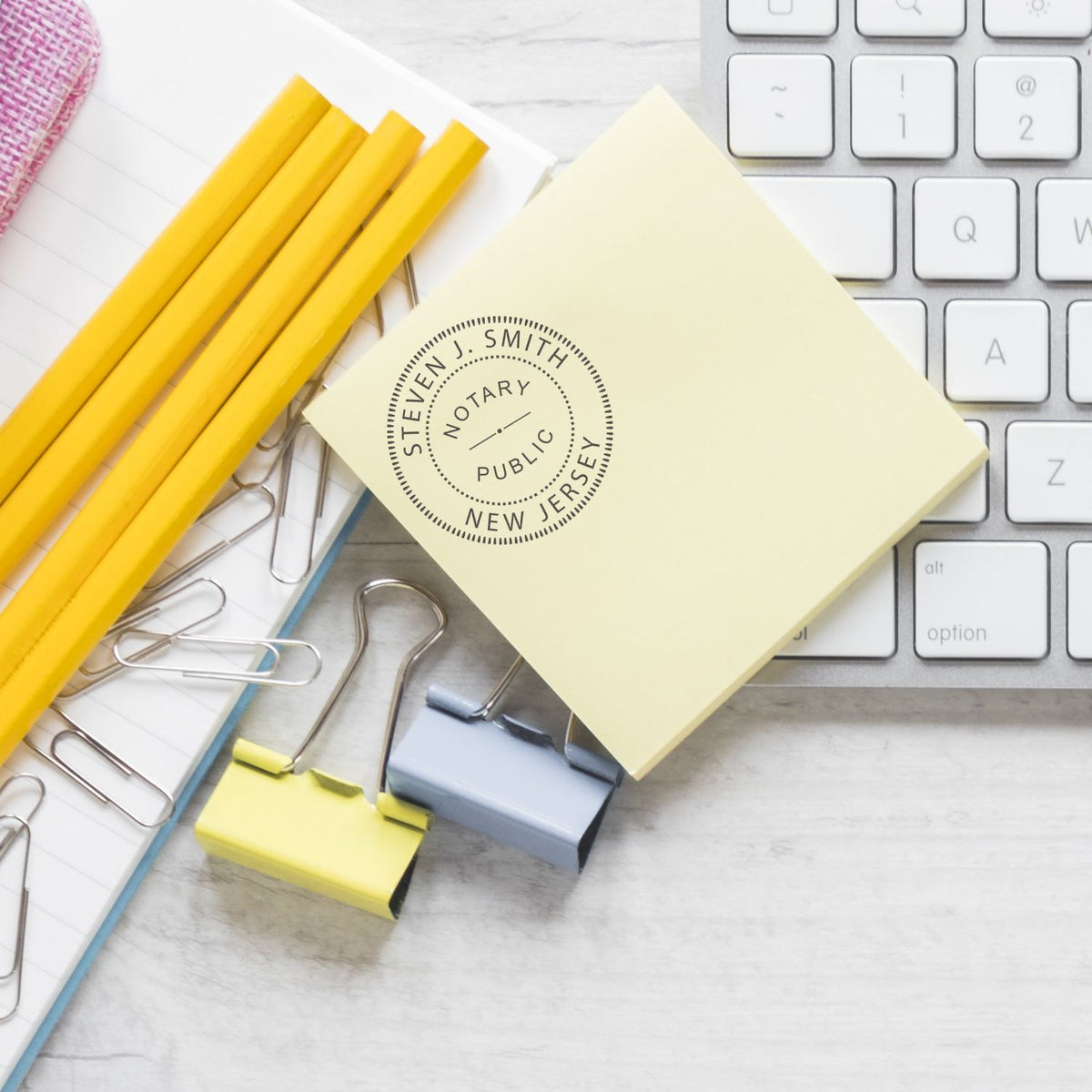 Notary public document seal for New Jersey on stationery with pencils, sticky notes, and keyboardoffice legal paperwork concept.