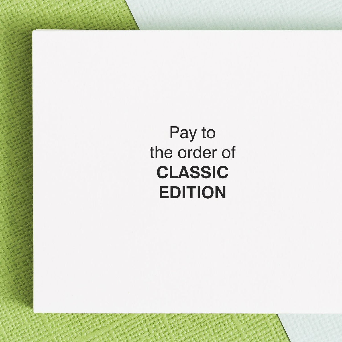 White classic edition blank card or check-style envelope on green textured background with Pay to the order of CLASSIC EDITION text.
