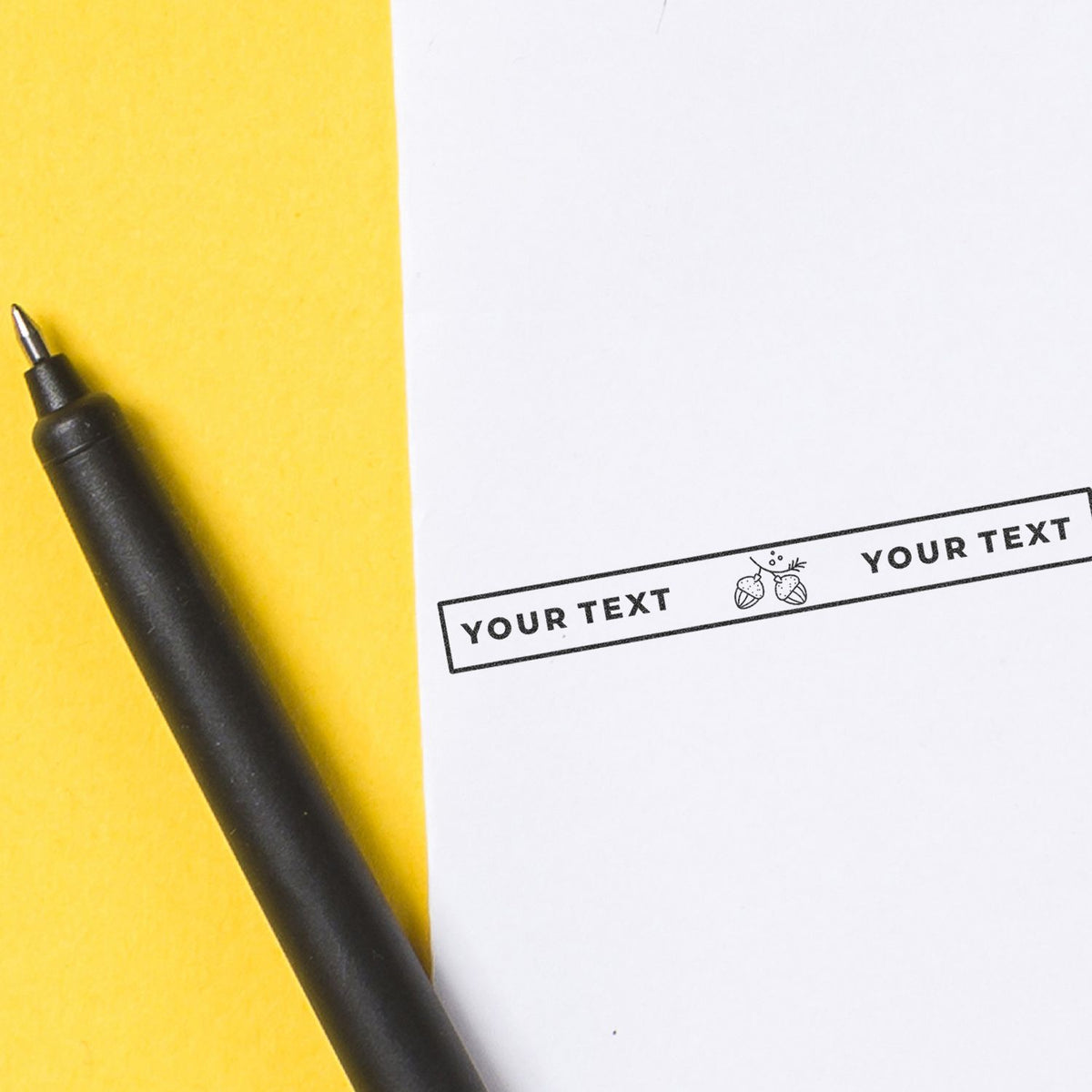 Black pen beside customizable stamp reading YOUR TEXT on yellow and white background for print design