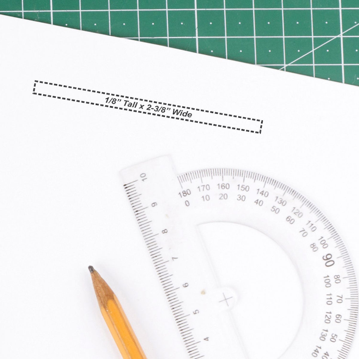 Drafting stencil template for hand lettering, marked 1/8 inch tall x 2-3/8 inch wide, with protractor and pencil for measurements.