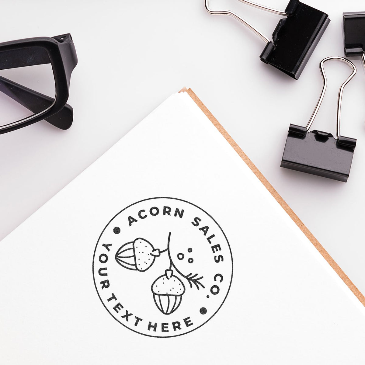 Acorn Sales stamp on white stationery mockup with pencil, stapler and binder clips, showing office branding design layout for marketing
