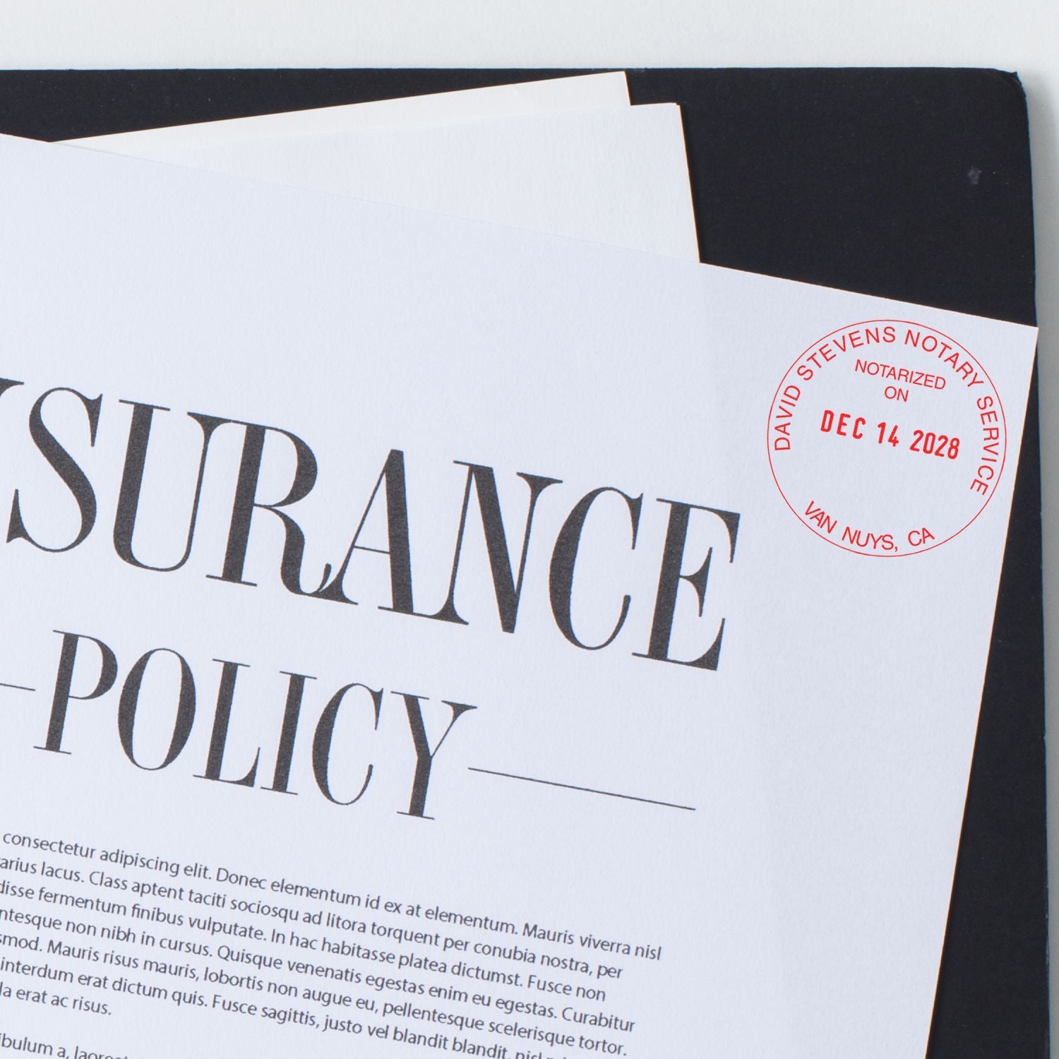 Insurance policy document with red notarized stamp and legal paperwork close-up.