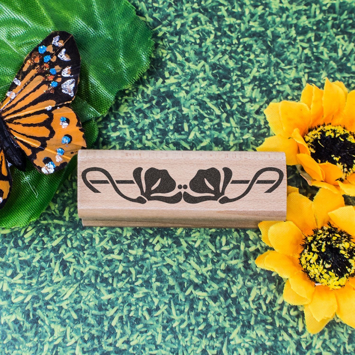 Butterfly and sunflower decorative rubber stamp on a green floral background