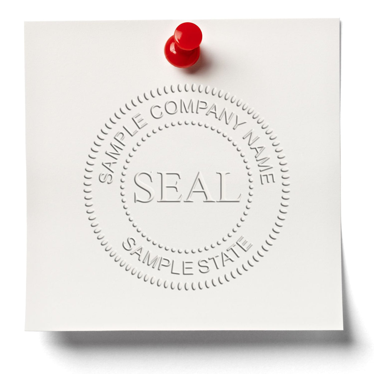 Embossed company seal stamp sample on white paper pinned with a red pushpin.