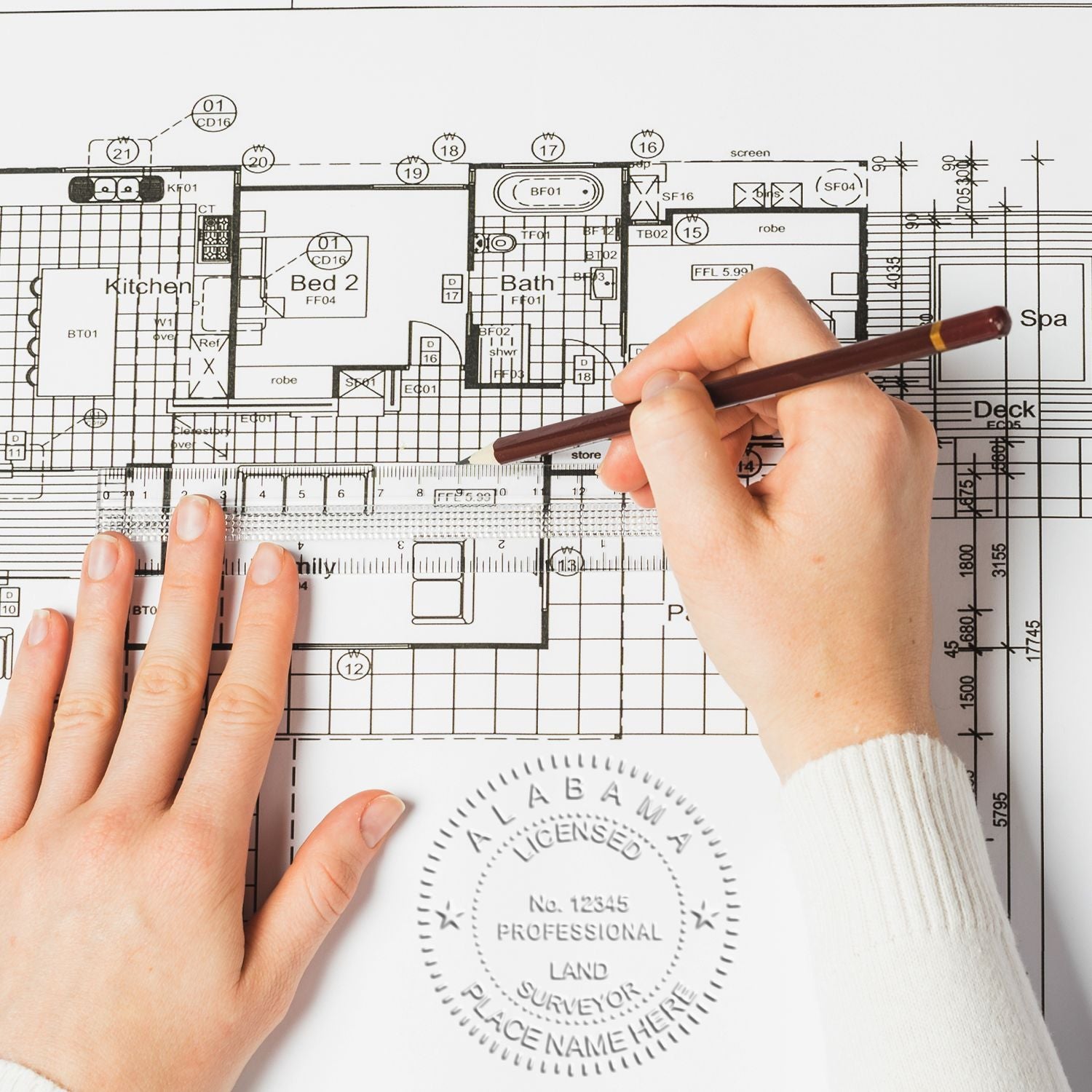 Hands drawing on an architectural floor plan with pencil and ruler, showcasing home design and blueprint planning.