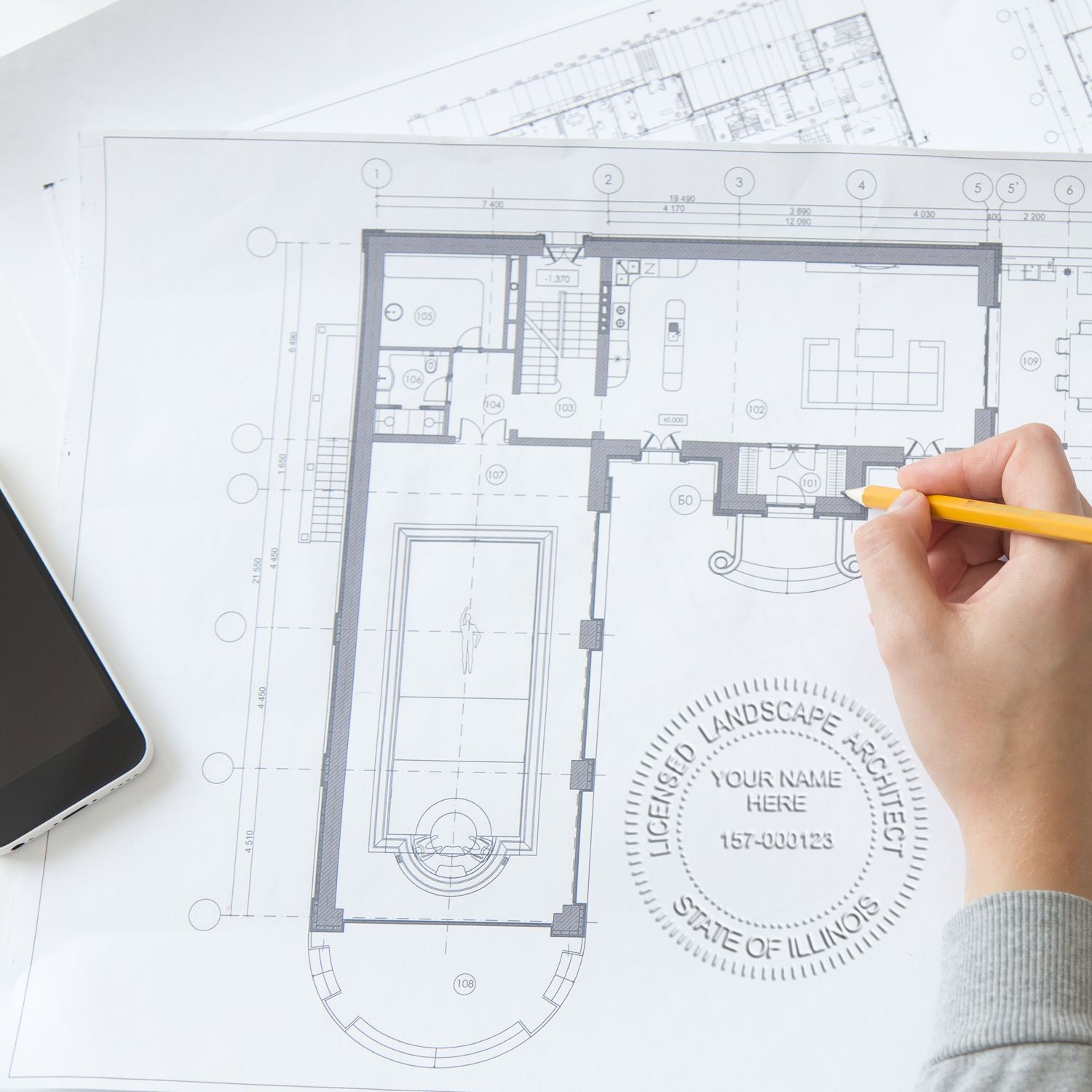 Architectural floor plan blueprint with hand holding pencil for home design and renovation planning.