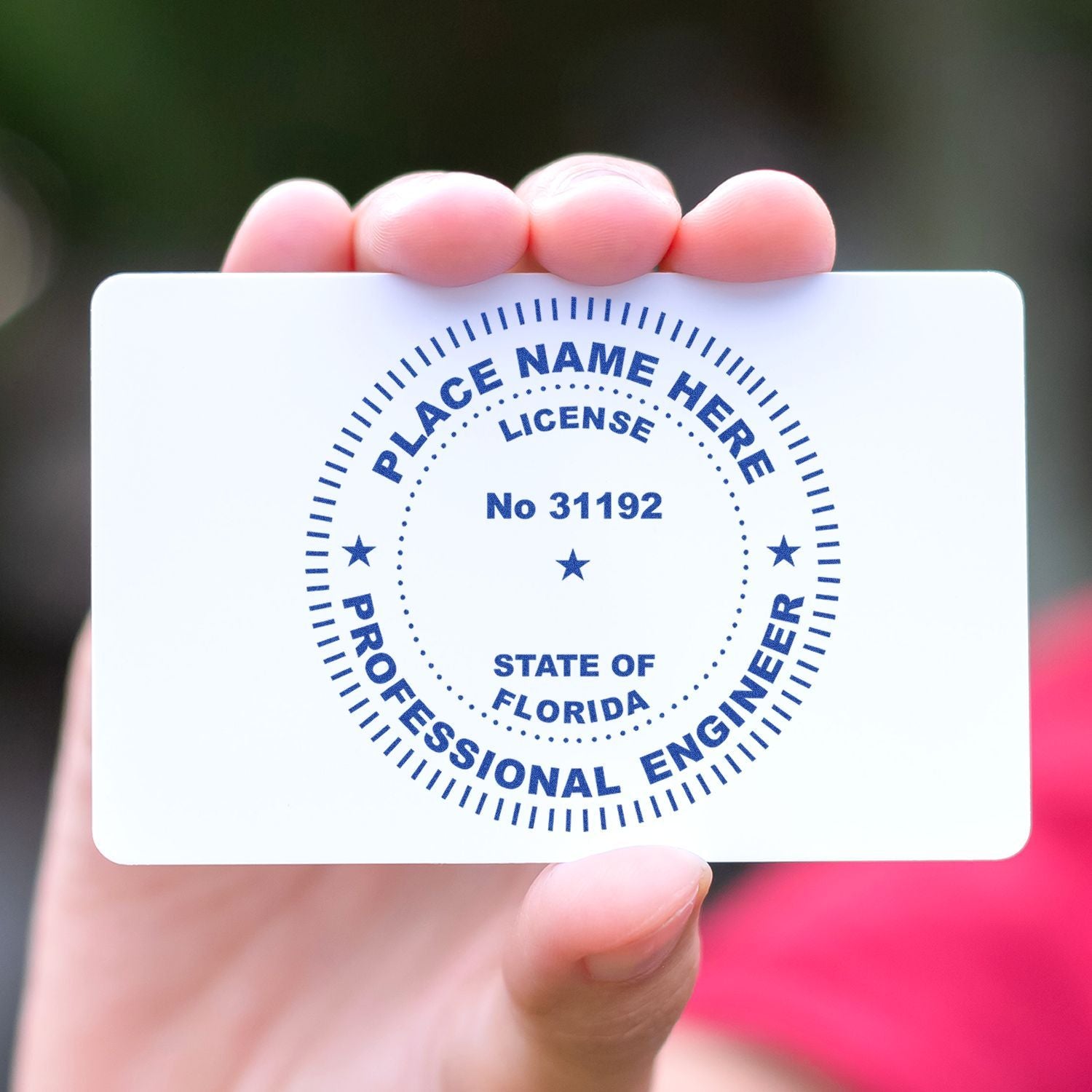 Hand holding Florida professional engineer license card with placeholder name and license number.