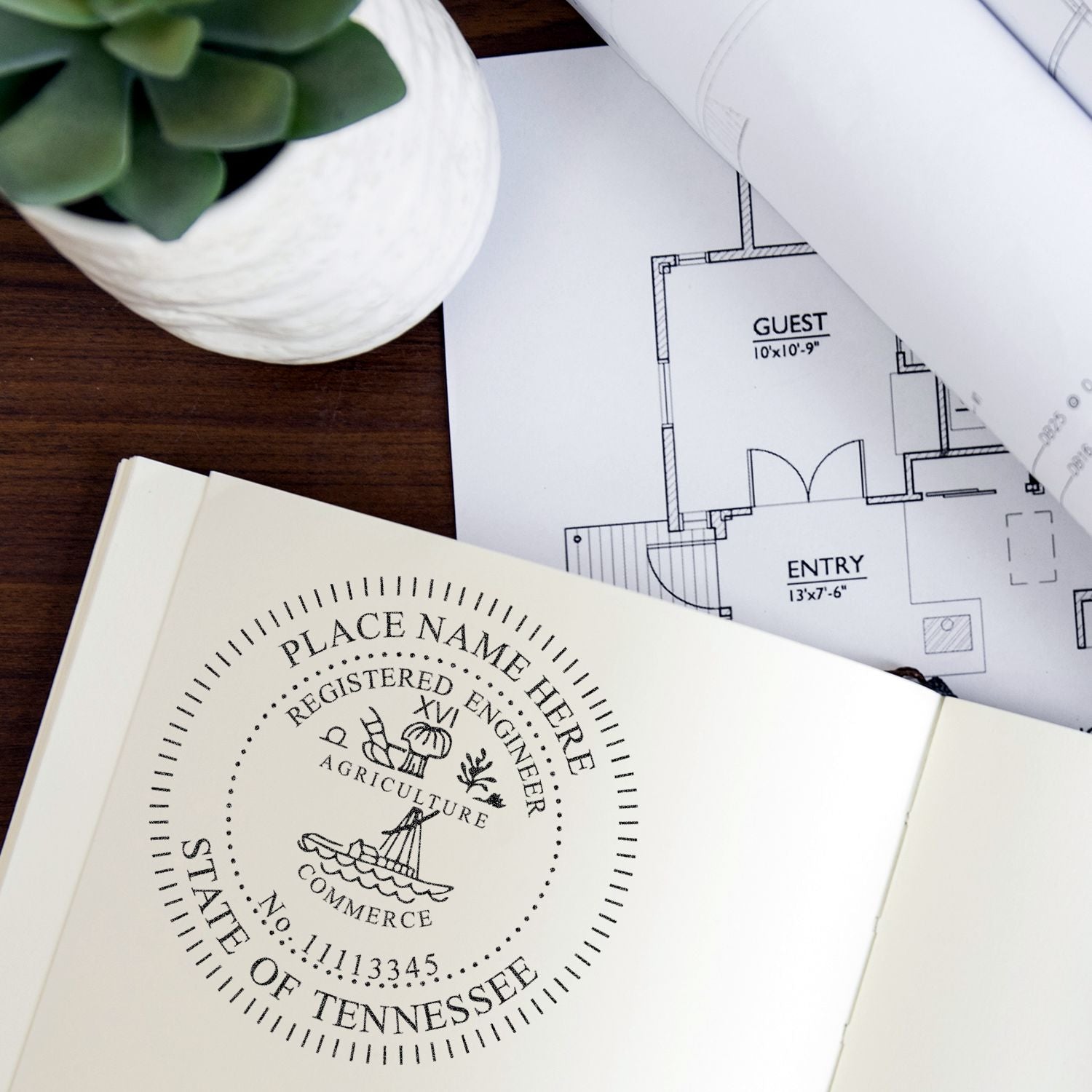 Architectural floor plans with Tennessee registered engineer seal, home design blueprint, and notebook on a desk.