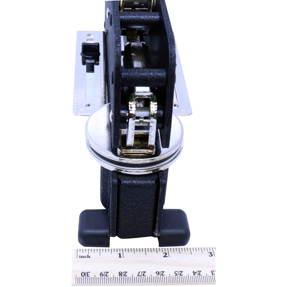 Close-up of a black metal wheel assembly with chrome hardware and ruler for size reference on a white background