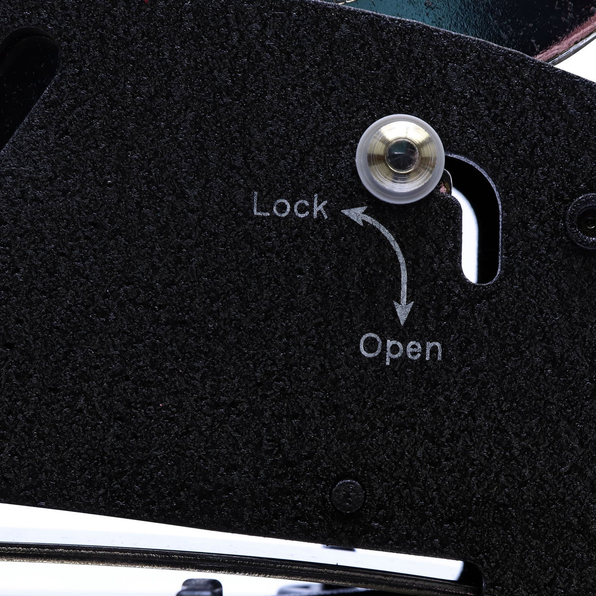 Close-up of black textured lock mechanism with lock and open indicators on a metal device.