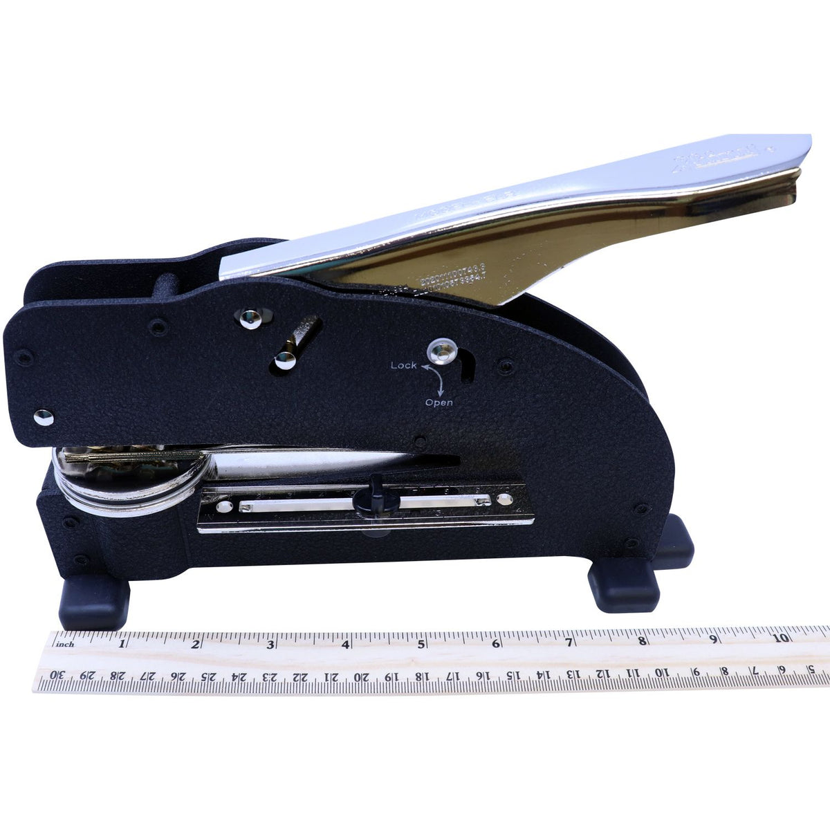 Heavy-duty paper hole punch with black metal body and silver lever, shown with ruler for size reference