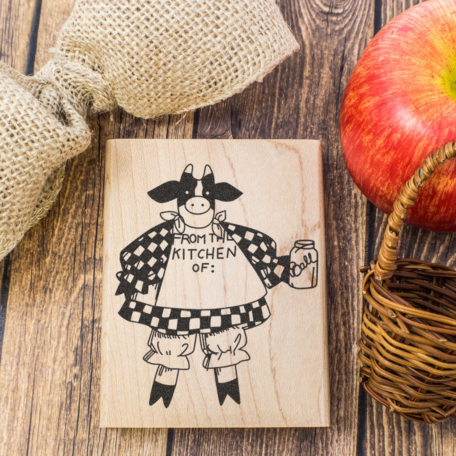 Rustic personalized wooden kitchen sign with cow design, apple, and burlap decor on a farmhouse wood background