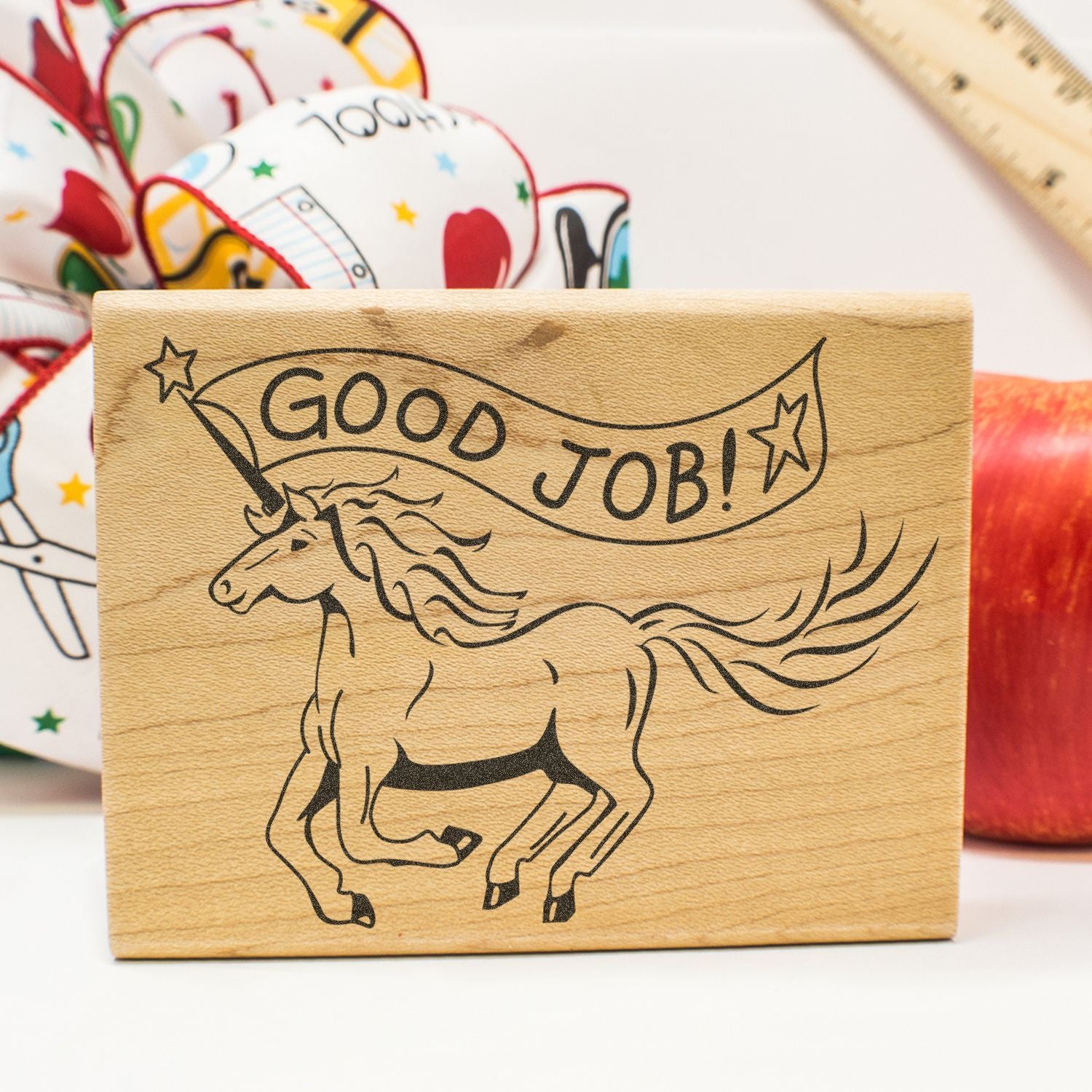 Wooden Good Job! unicorn stamp with stars, shown with colorful craft supplies on a white background.