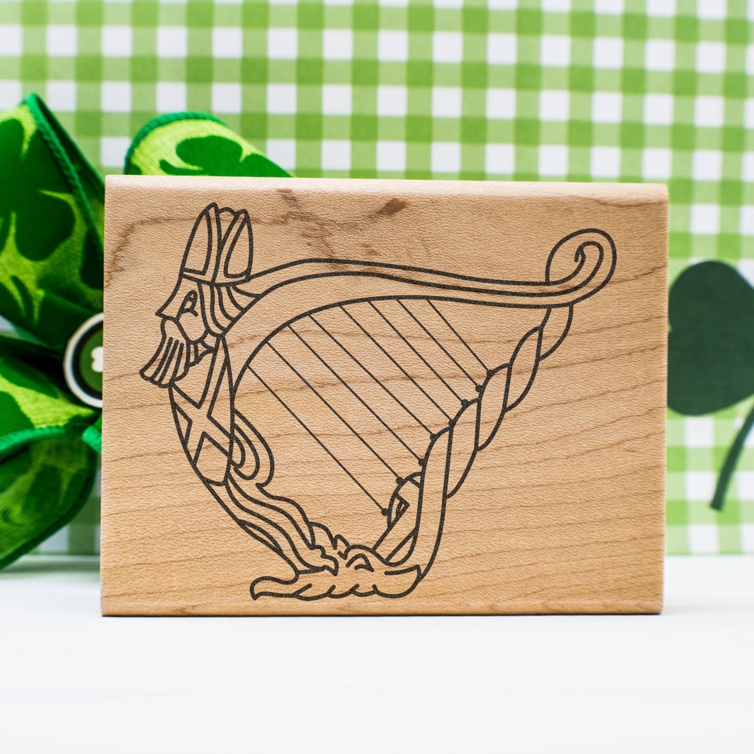 Wooden stamp block engraved with a detailed uterus anatomy illustration on a green checkered background.