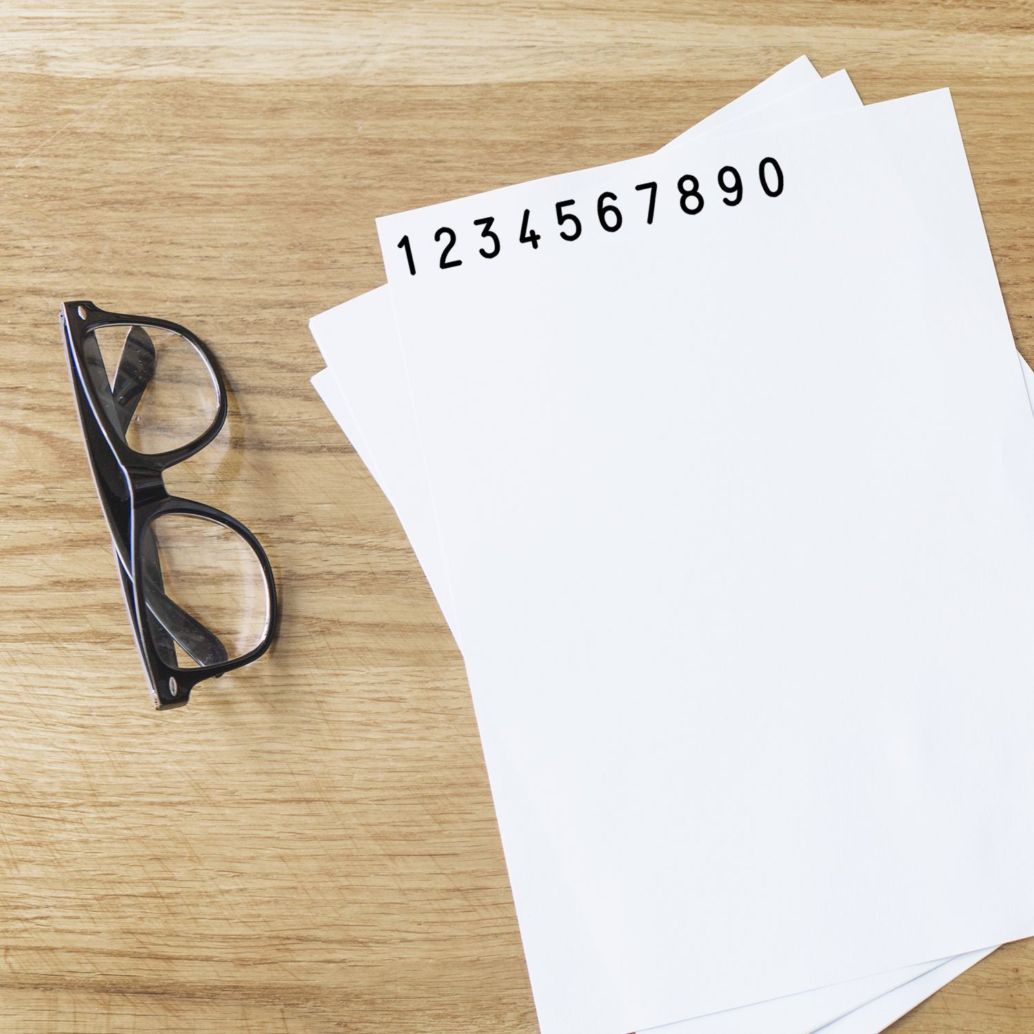 Printed numbers 1234567890 on paperwork with eyeglasses on wooden desk, representing data entry and accounting.