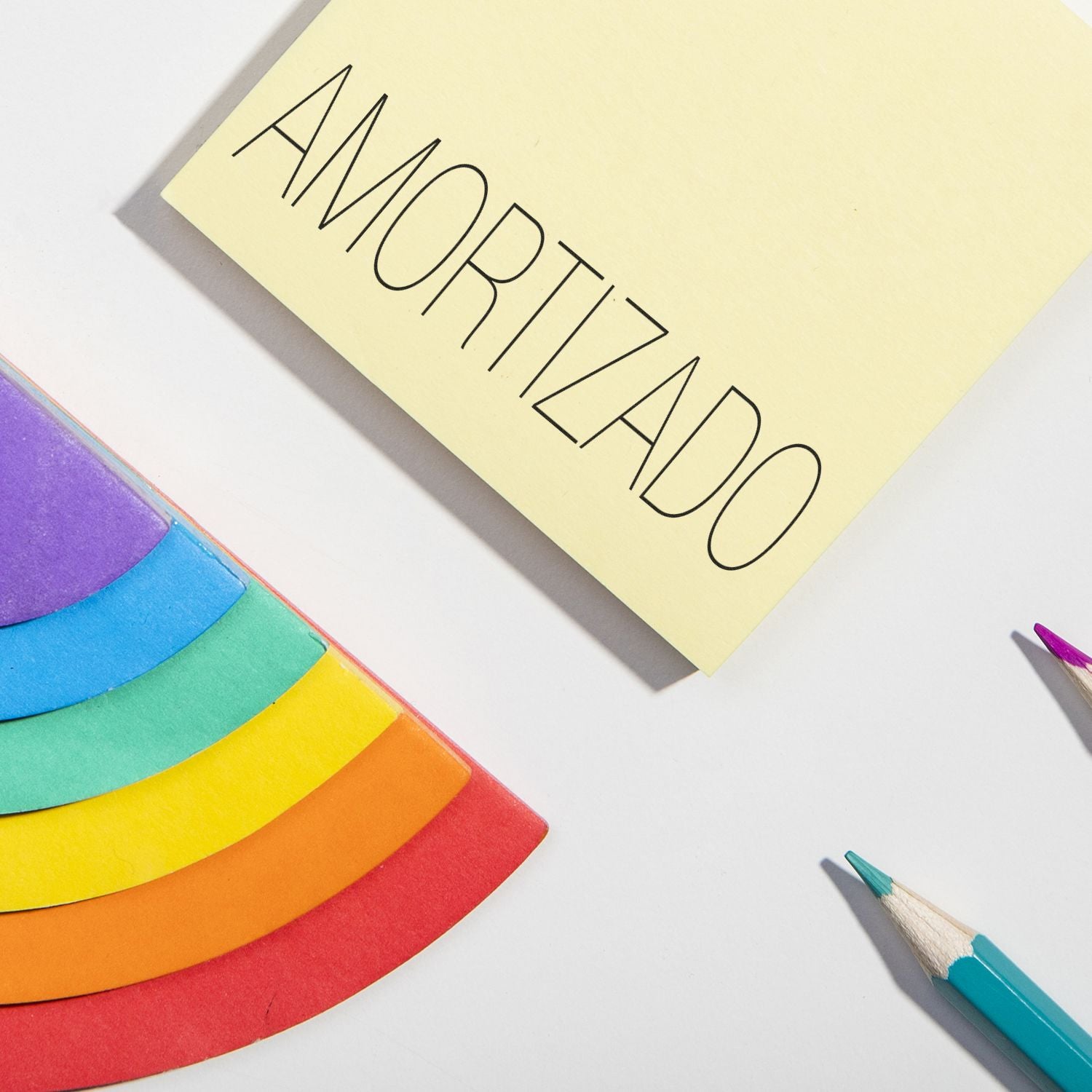 Colorful sticky notes with rainbow design and pencil beside a note labeled AMORTIZADO on a white background.