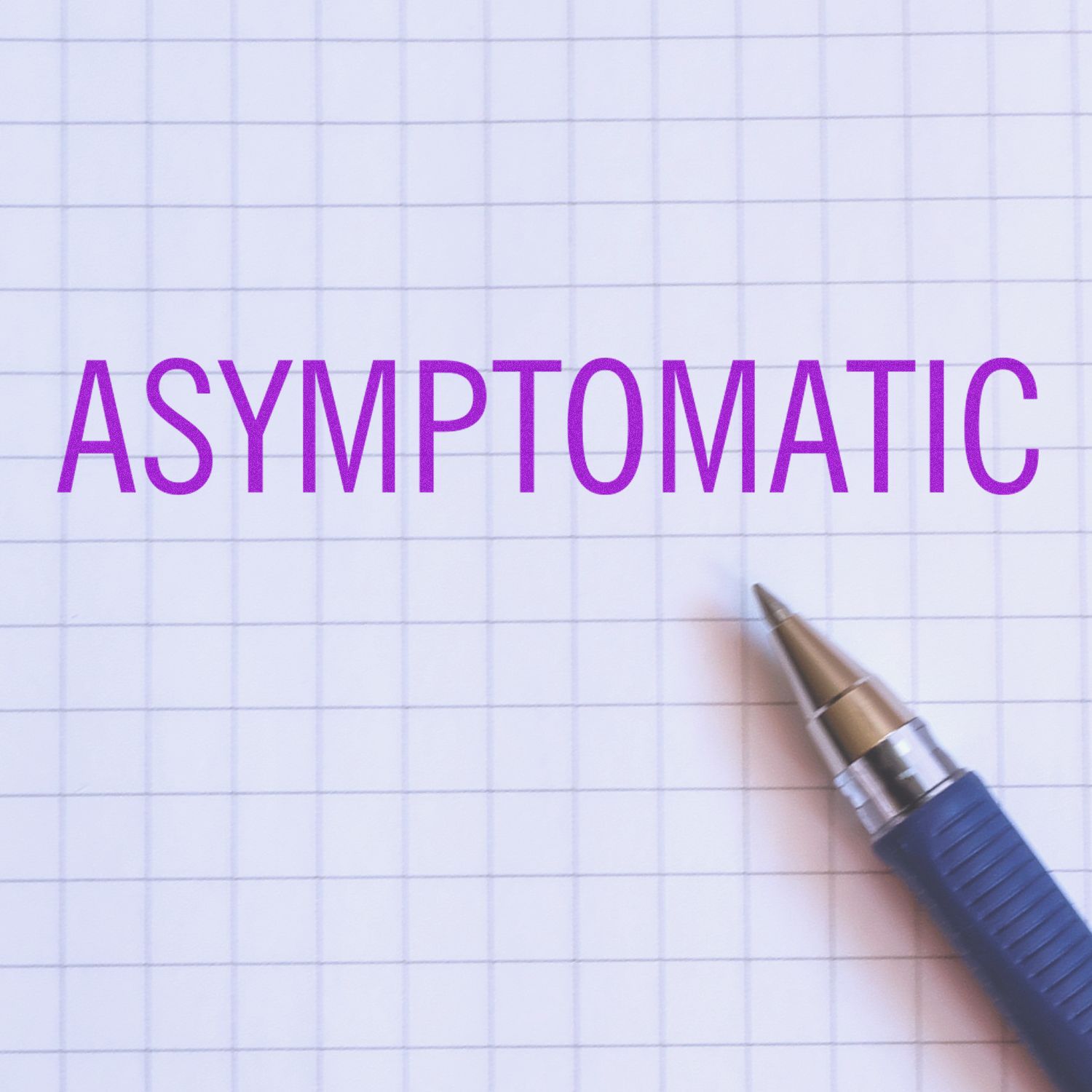 Purple ASYMPTOMATIC text on blue grid paper with a pen, symbolizing asymptomatic health conditions and medical screening.