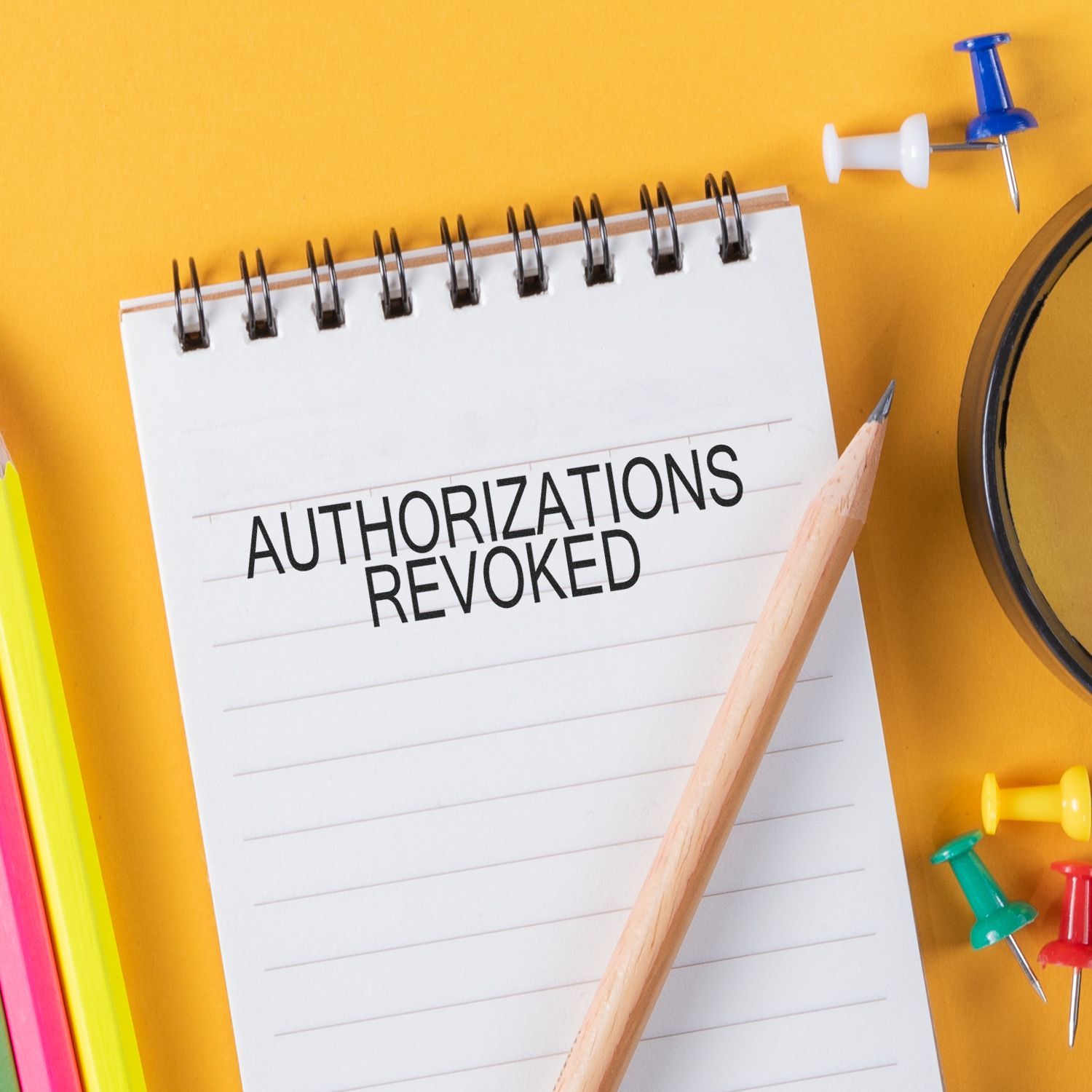 Notebook page stamped Authorizations Revoked with pencil and pushpinscompliance and policy notification for security.