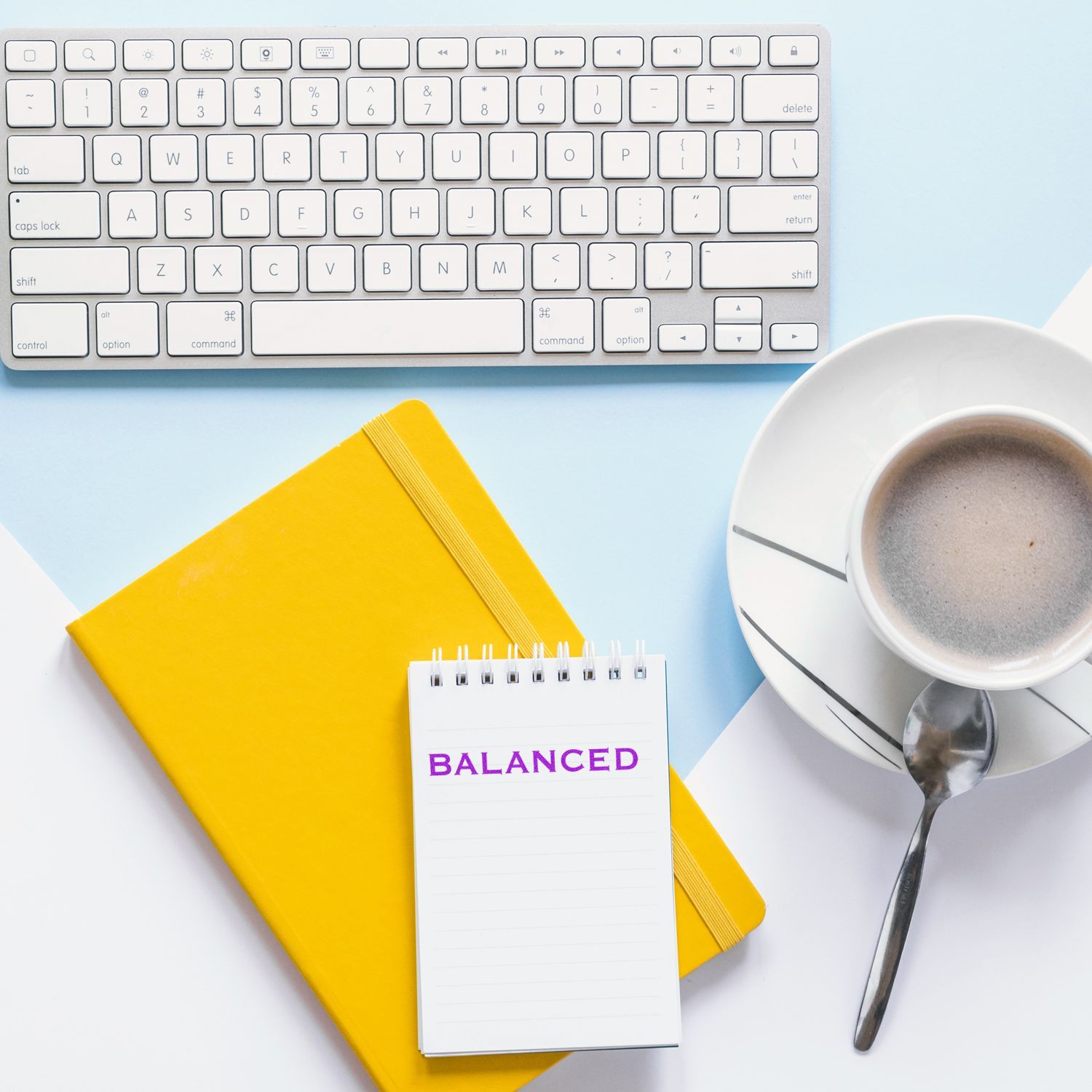 Keyboard and Balanced planning notebook with coffee on deskwork-life balance and productivity workspace for goal setting