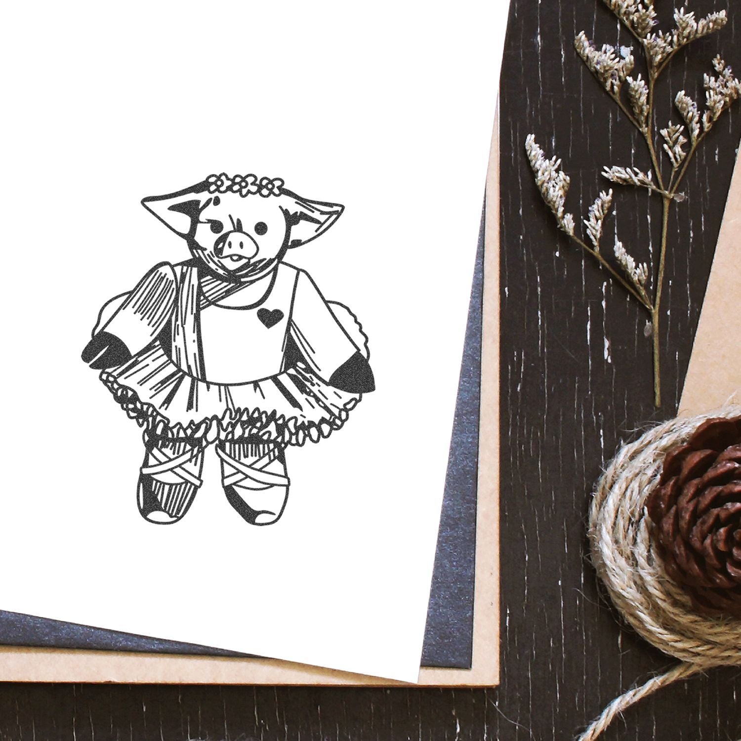 Cute pig illustration on a handmade greeting card with rustic craft decor and natural twine accents.