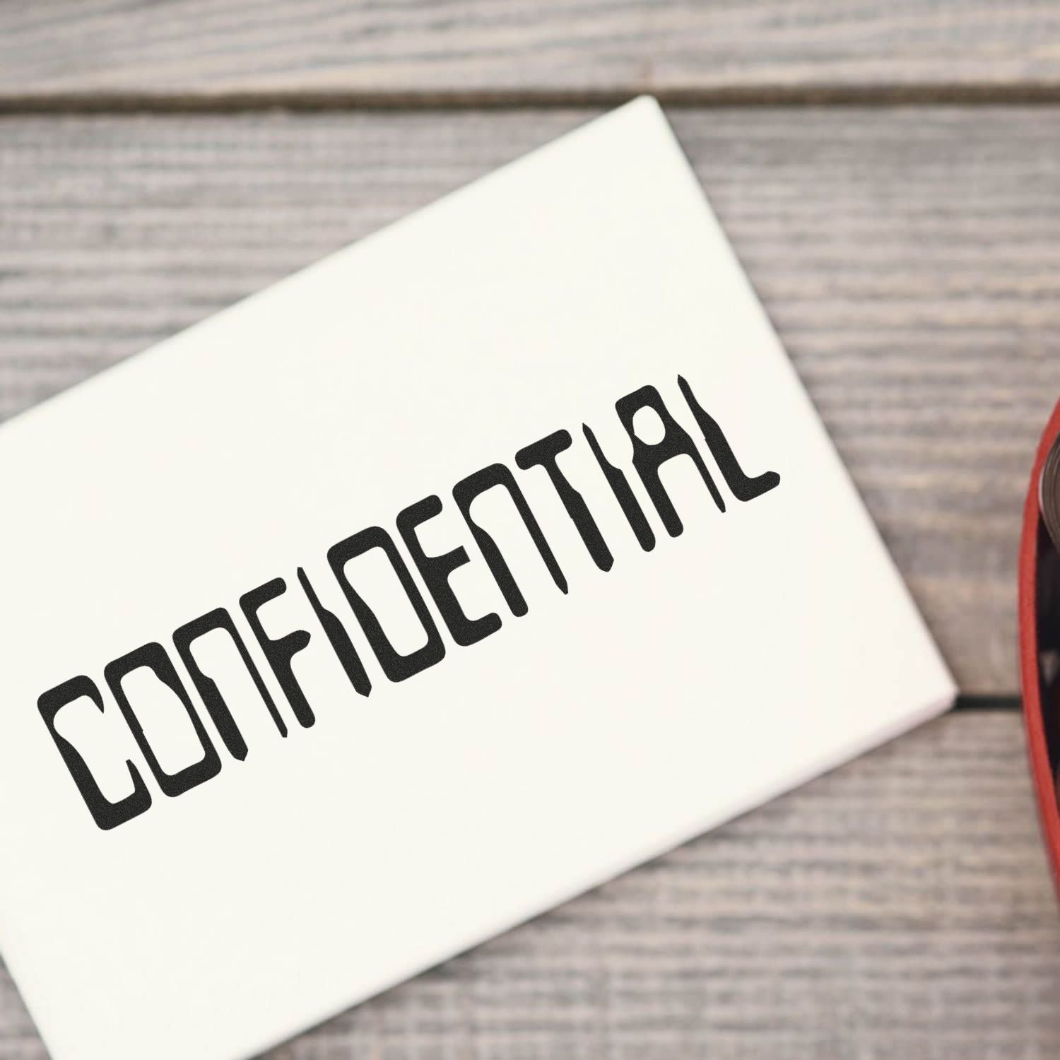 White laptop with CONFIDENTIAL label on a wooden desk, business security concept.