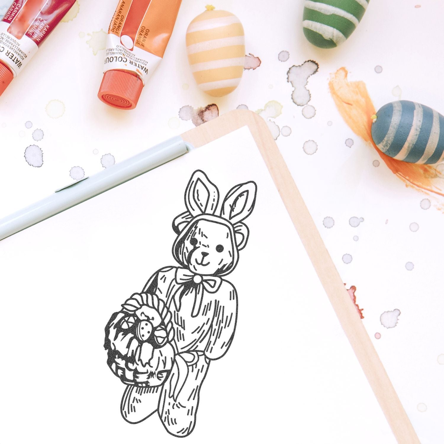 Cute Halloween bunny illustration in a sketchbook with watercolor paint tubes and painted Easter eggs on a creative art background