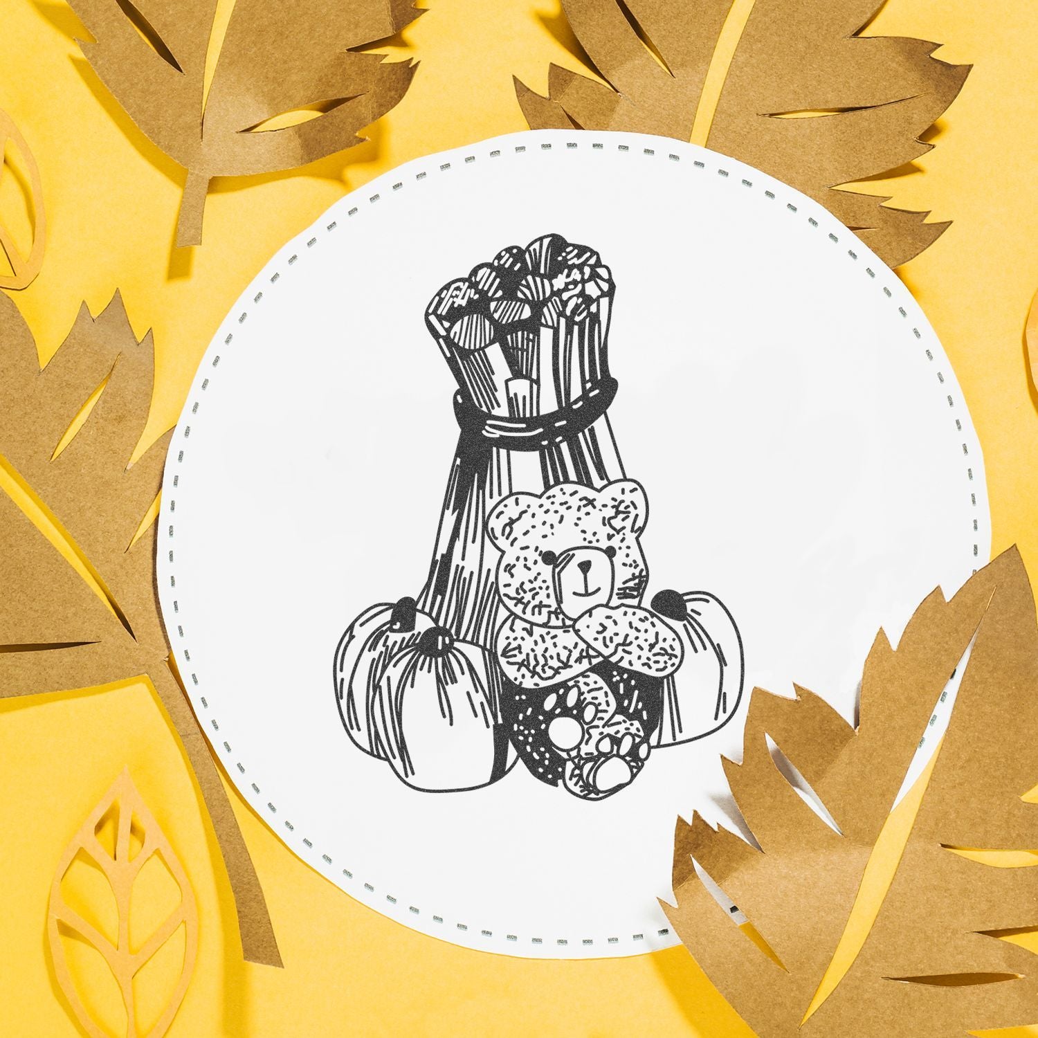 Halloween paper craft with teddy bear, pumpkin and bouquet illustration on a white circle surrounded by autumn leaves on a yellow background