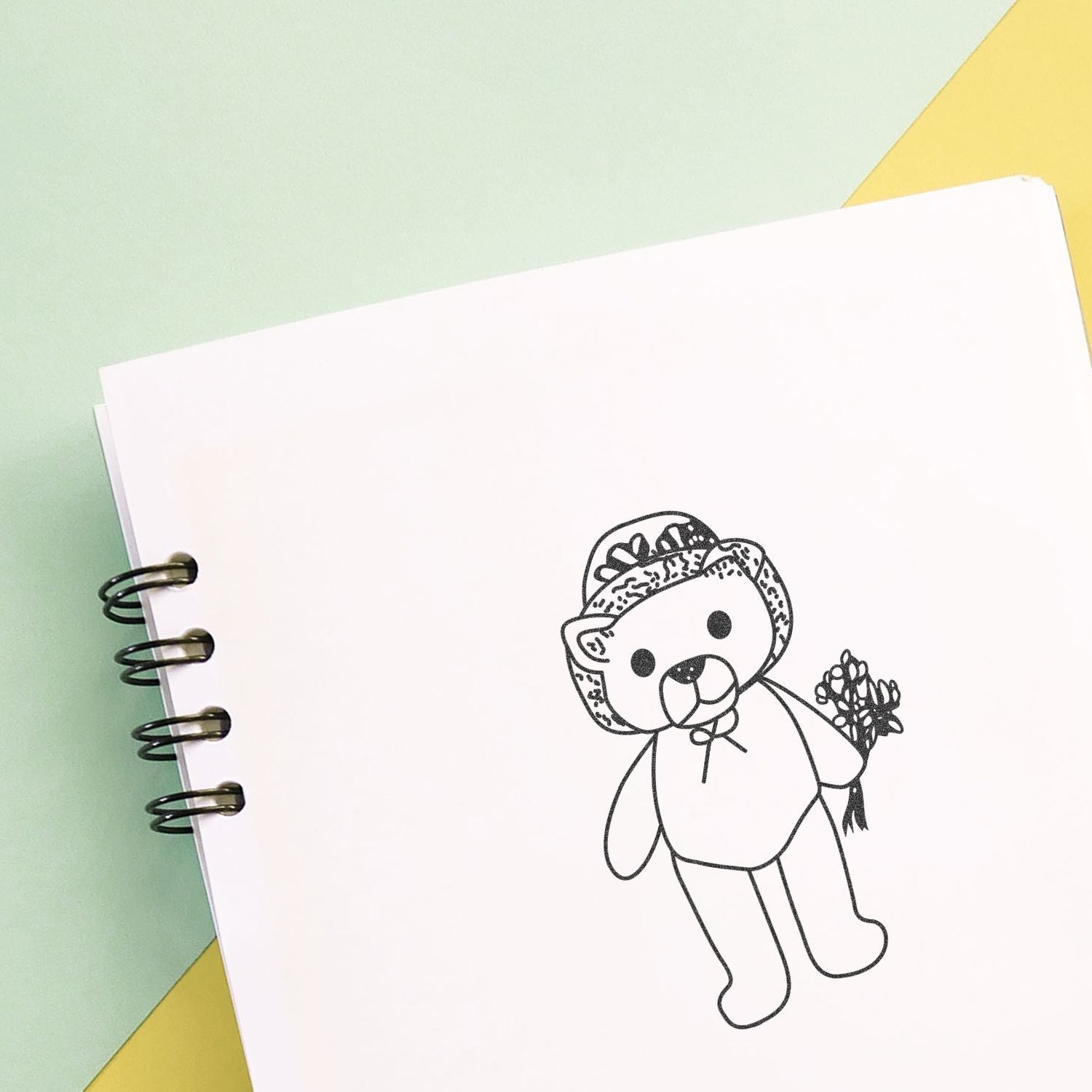 Spiral notebook with cute teddy bear line art holding flowers on a pastel background