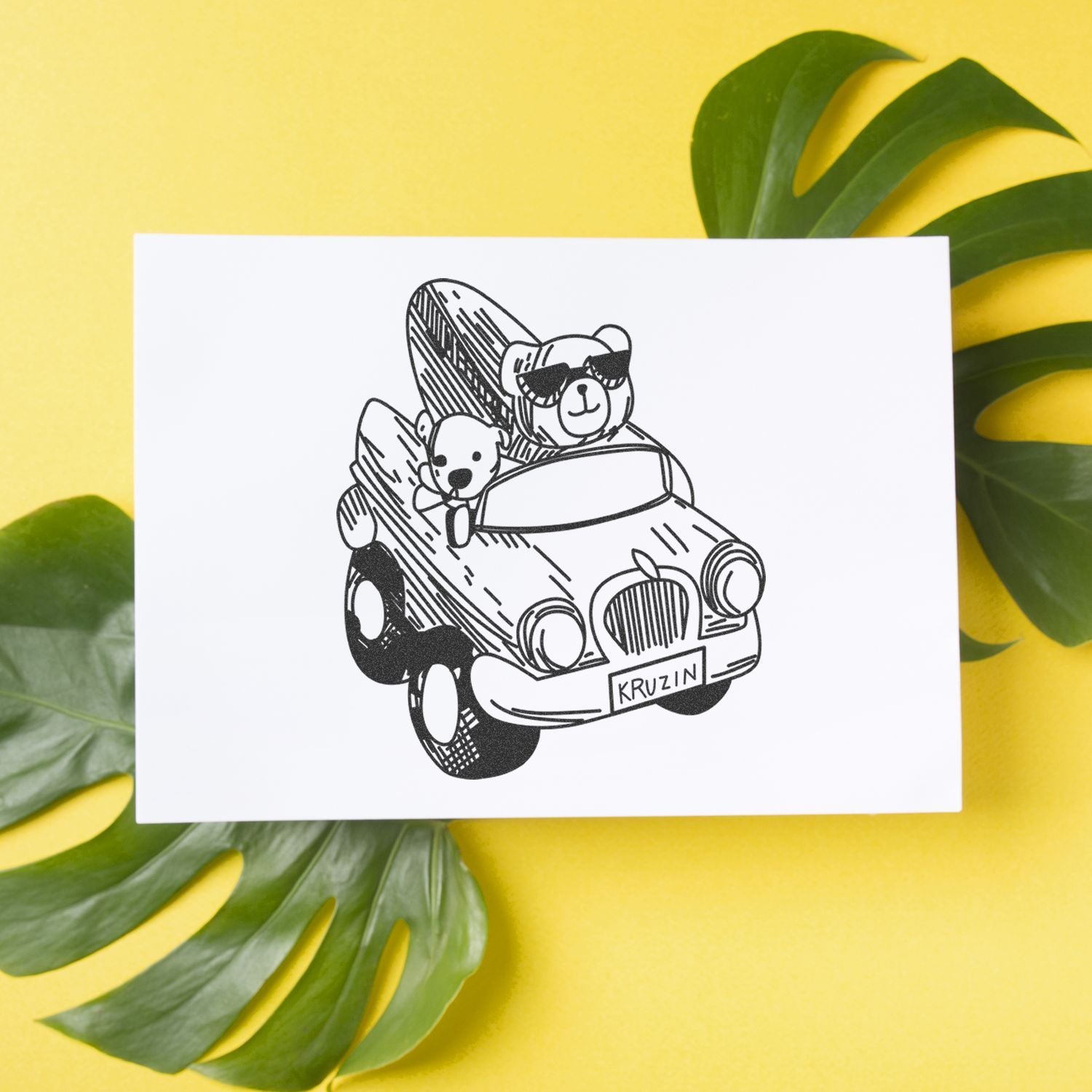 Cute teddy bear car illustration on a white greeting card with green tropical leaves on a yellow background.