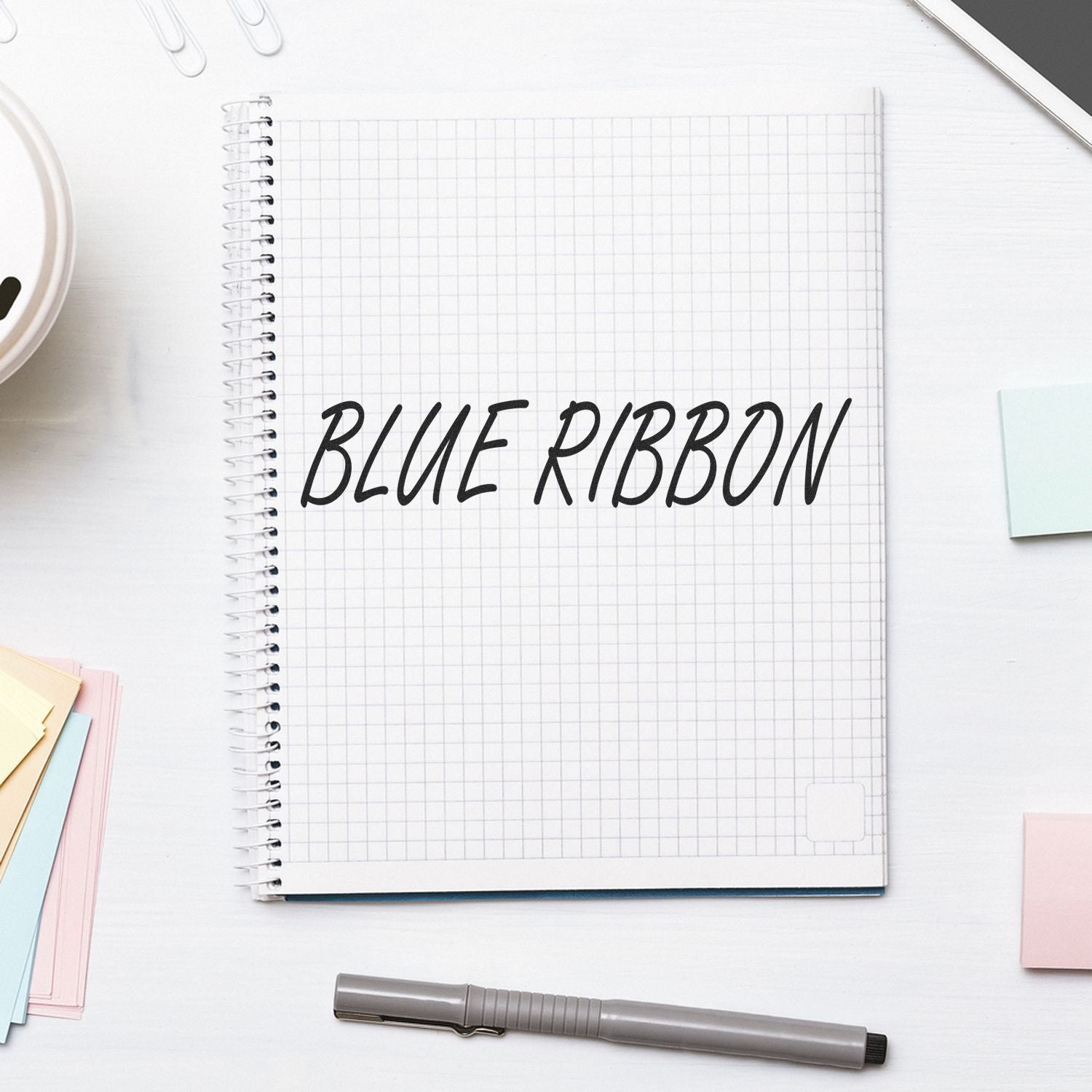 Blue Ribbon handwritten title on open grid notebook, representing awards, school notes, and exam preparation.