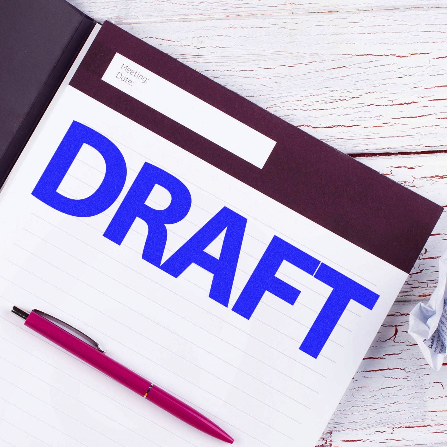 Meeting planner page with bold DRAIN label and pen on white desk, for maintenance scheduling and task organization