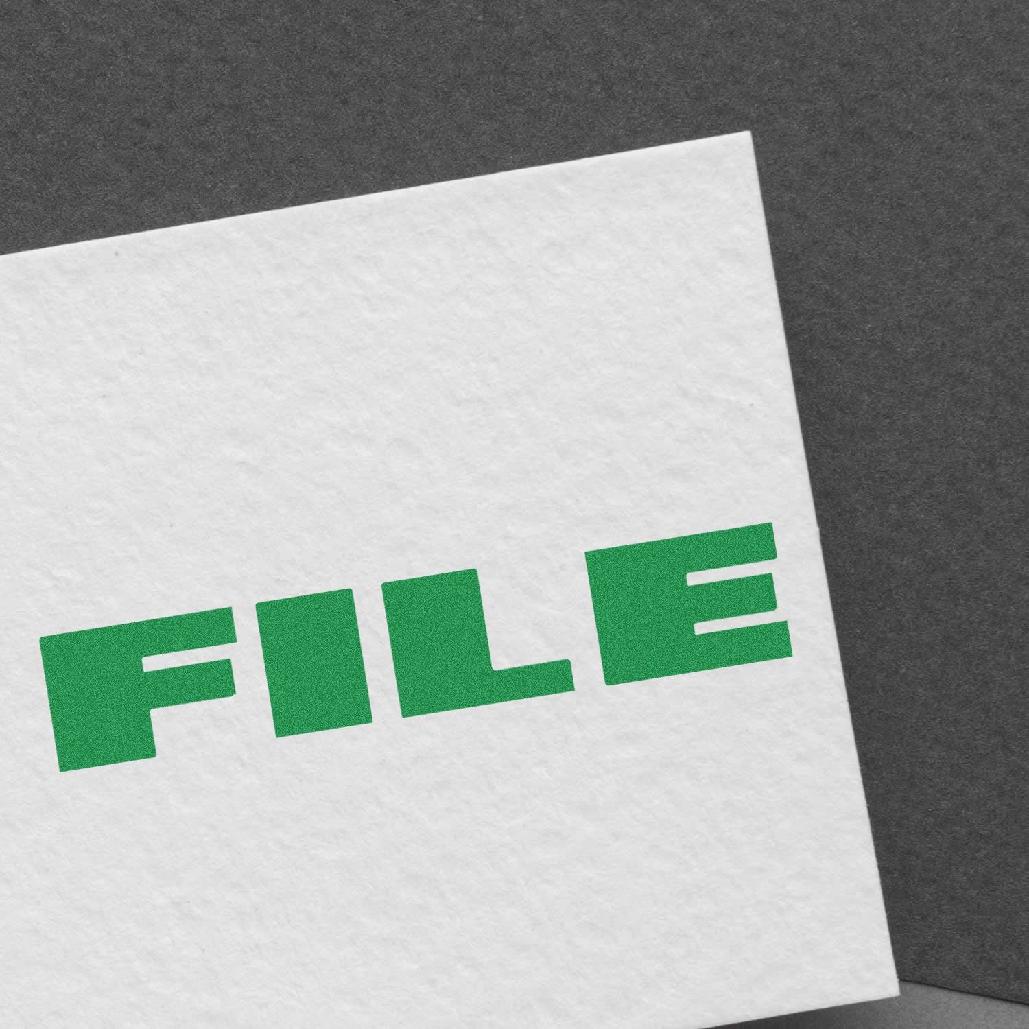 Close-up of white paper with green FILE text on a dark background.