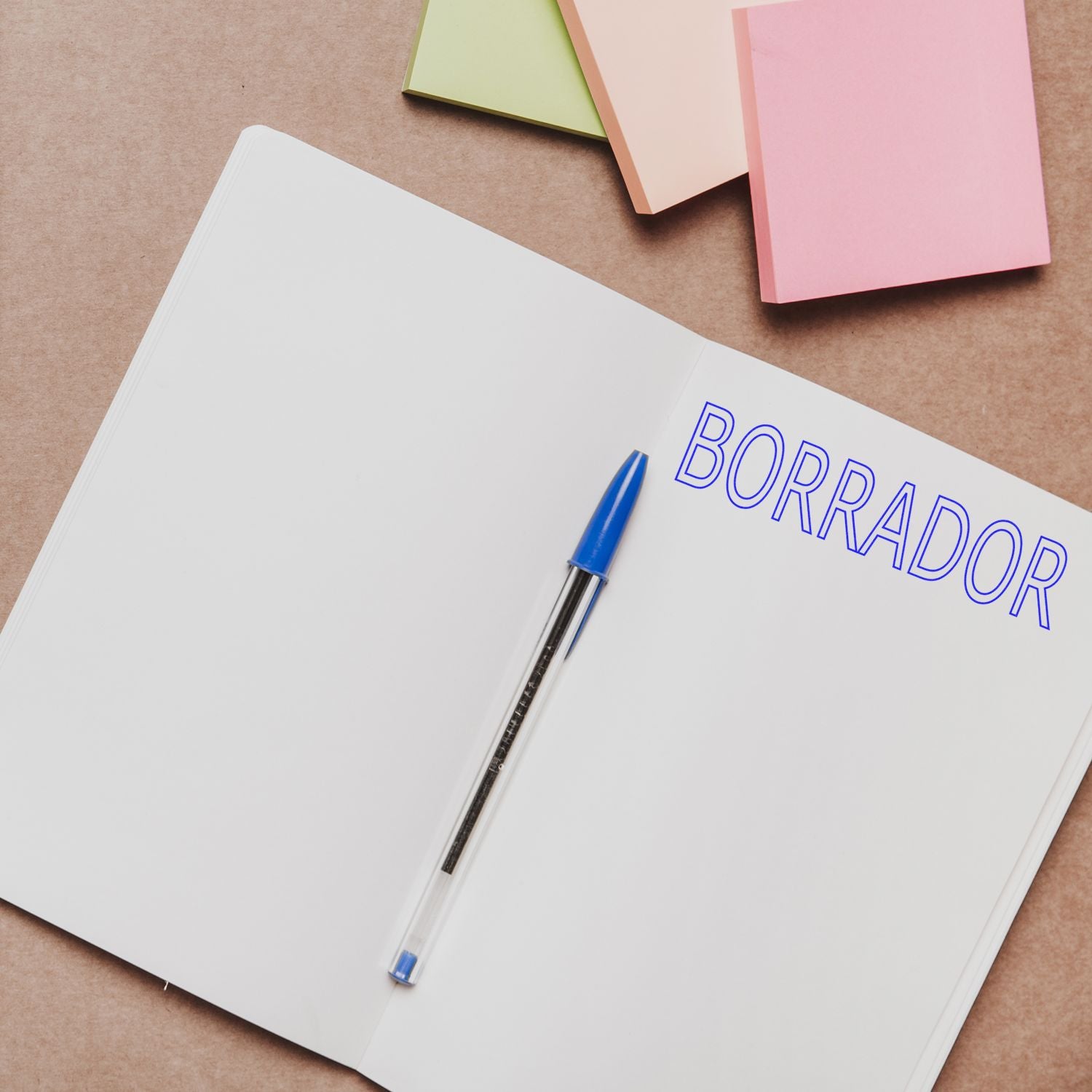 Notebook page labeled BORDADOR with a blue pen and pastel paper sheets, promoting writing and planning ideas.