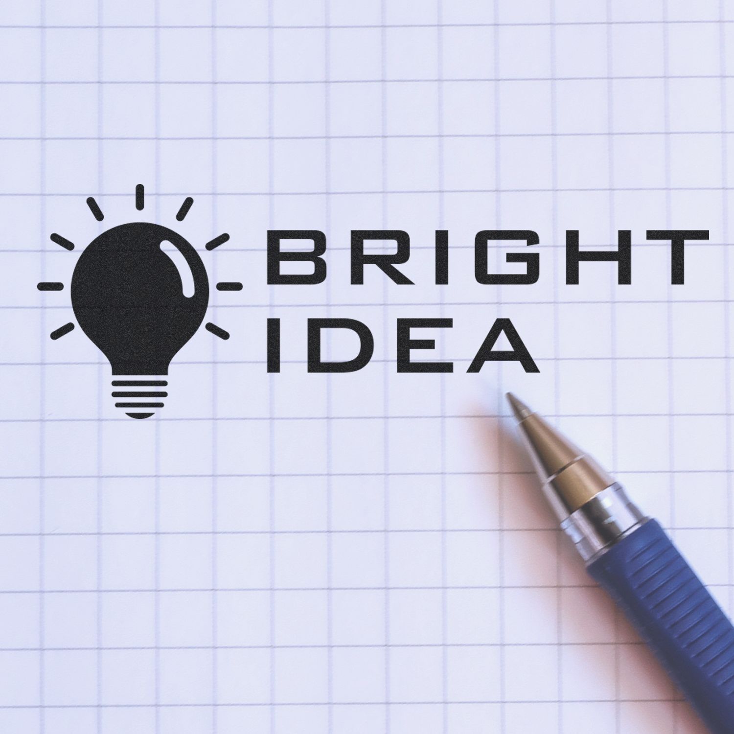 Bright idea concept with light bulb icon and pen on graph paper, creative brainstorming and innovation theme.