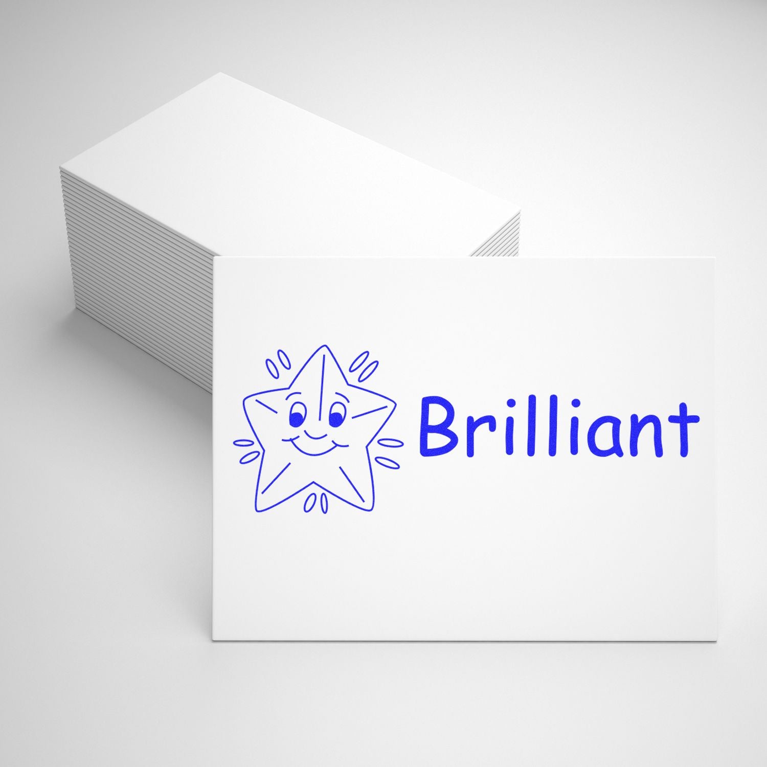 Brillant brand marketing stationery with blue smiling star logo on stacked white cards, representing premium quality paper.