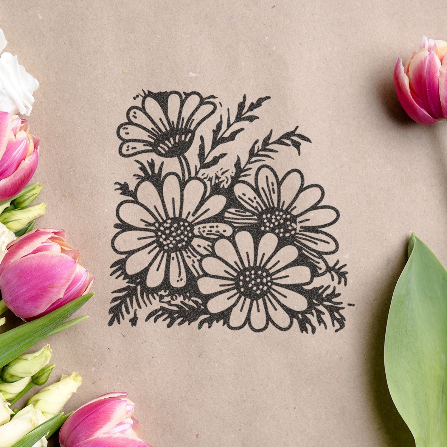 Black floral daisy illustration on kraft paper surrounded by pink tulips and green leaves, floral design background.
